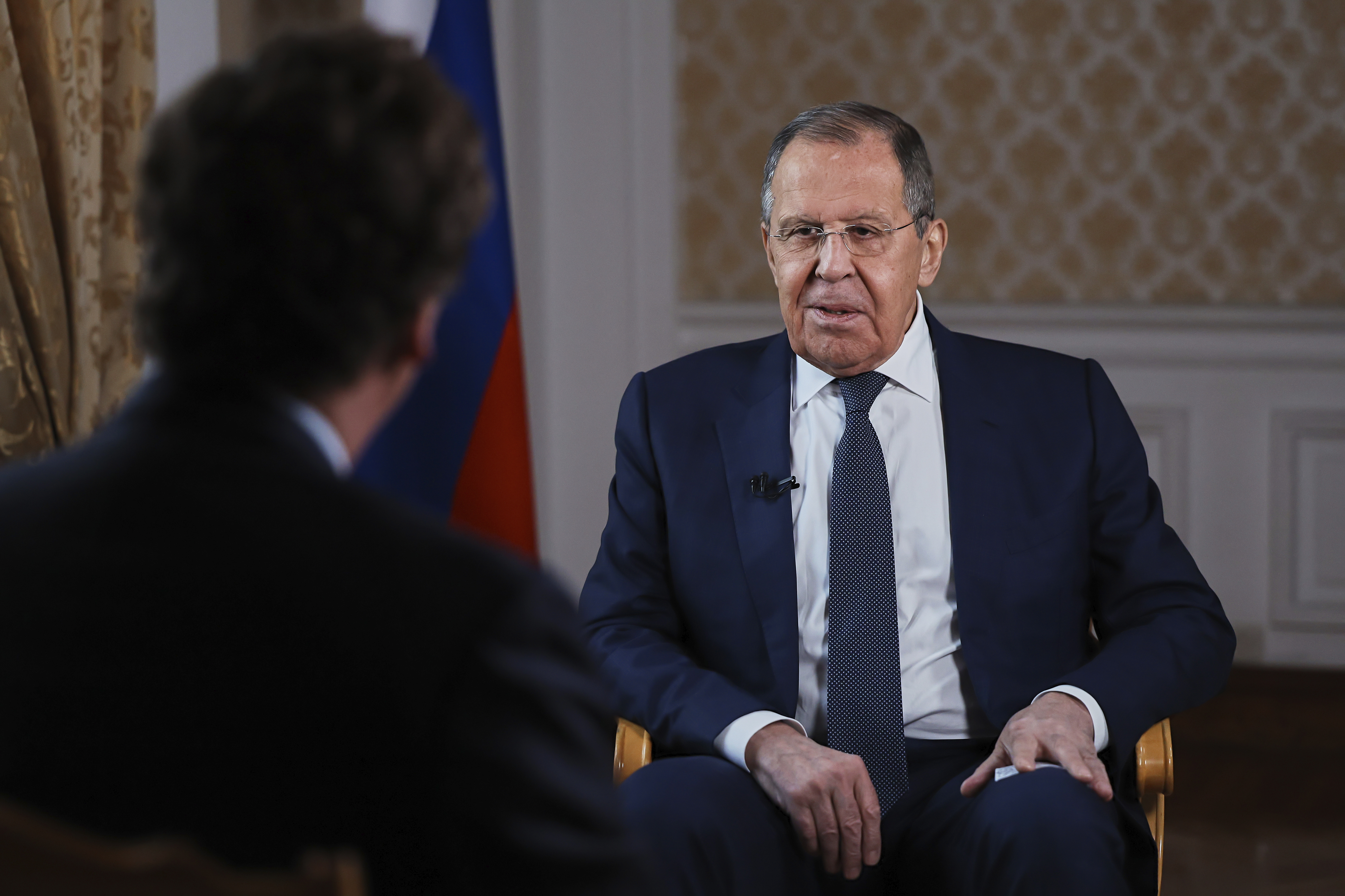 In this photo released by Russian Foreign Ministry Press Service, Russia's Foreign Minister Sergey Lavrov, speaks during an interview with former Fox News host Tucker Carlson, back to a camera, in Moscow, Russia on Tuesday, Dec. 3, 2024. (Russian Foreign Ministry Press Service via AP)