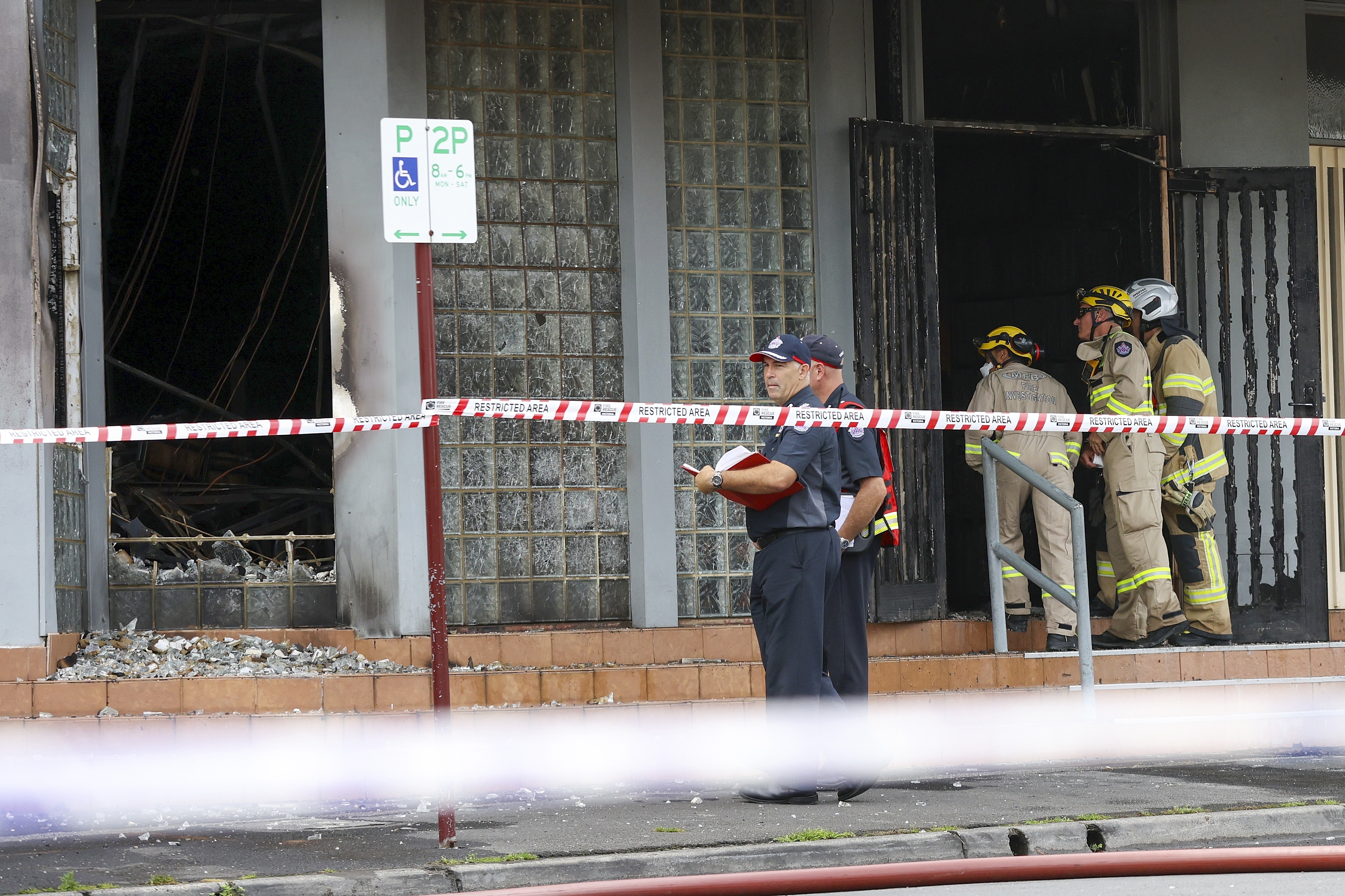 Fire crew members and police officers work the scene of a fire at Adass Israel Synagogue in the suburb of Ripponlea, Melbourne, Australia, Friday, Dec. 6, 2024. (Con Chronis/AAP Image via AP)