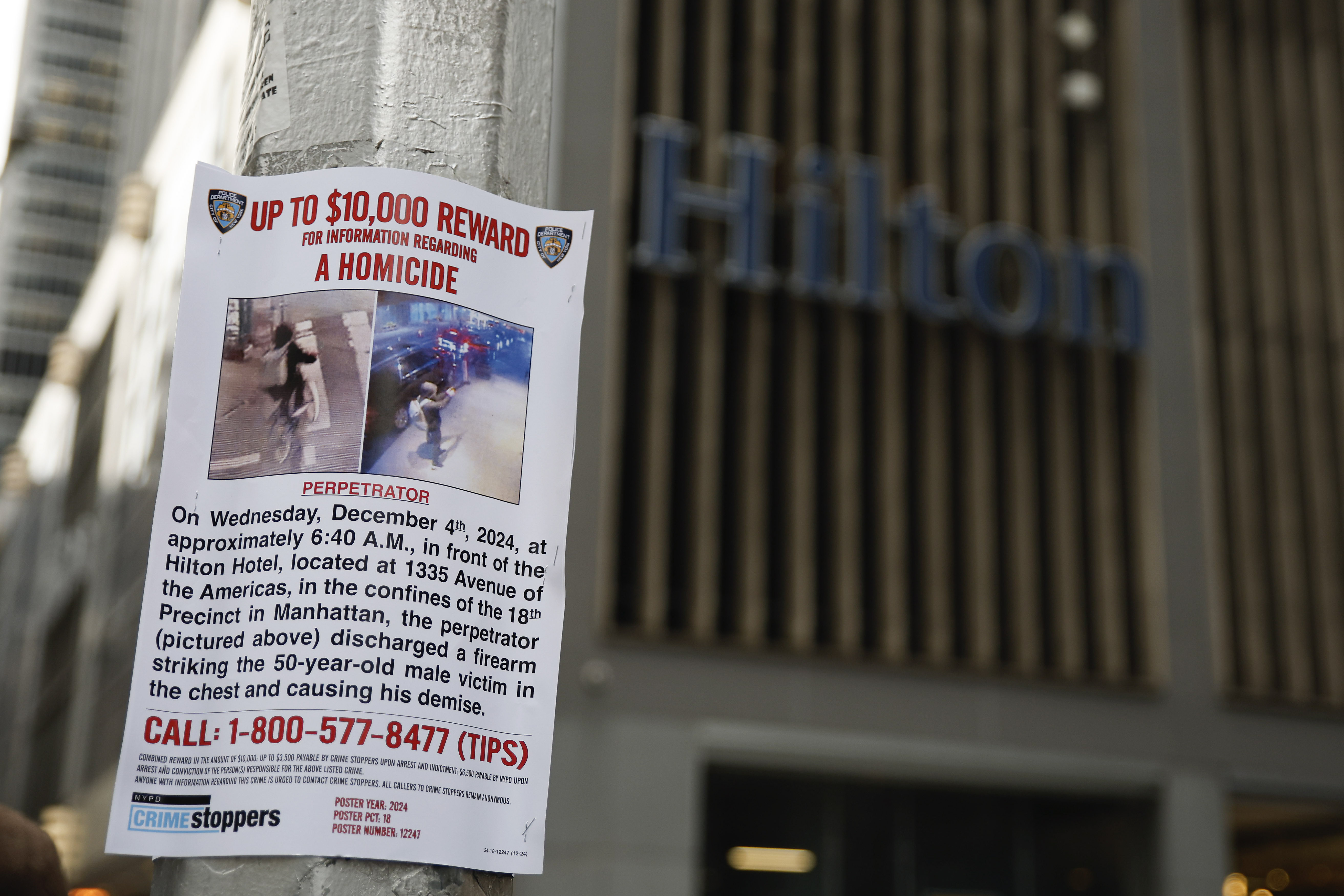 A reward poster hangs on a light pole outside the Hilton Hotel in midtown Manhattan where Brian Thompson, the CEO of UnitedHealthcare, was fatally shot ,Wednesday, Dec. 4, 2024, in New York. (AP Photo/Stefan Jeremiah)