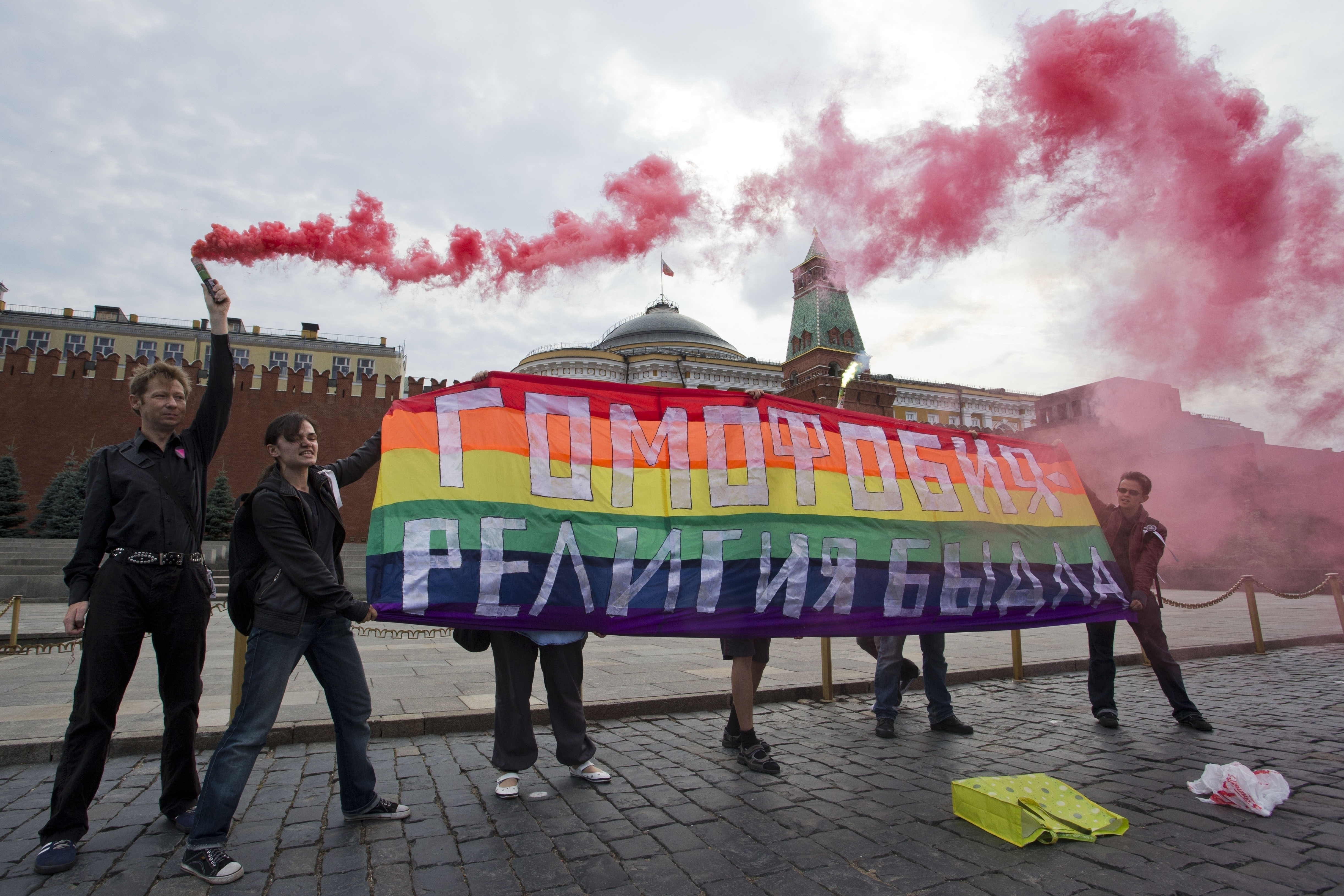 FILE - Gay rights activists hold a banner reading "Homophobia -- the religion of bullies" during a protest on Red Square in Moscow on July 14, 2013. (AP Photo/Evgeny Feldman, File)