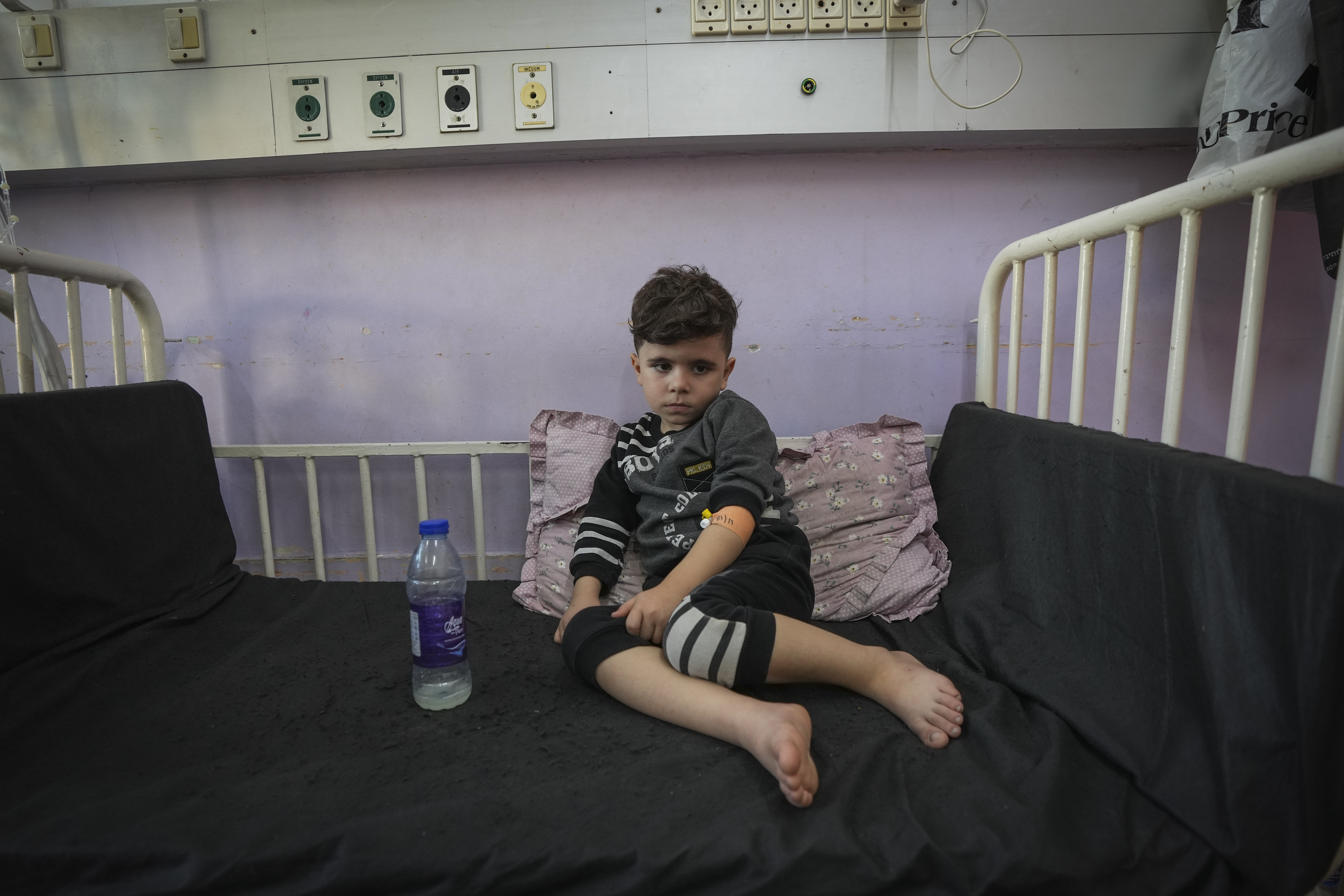 Qusay al-Askari, 4, sits in a bed in Deir al-Ballah, Gaza Strip, on Nov. 16, 2024. His mother Nima al-Askari said she was told by doctors that her son could become paralyzed if he doesn't get surgery in the next two or three months for a heart defect that constricts his aorta. (AP Photo/Abdel Kareem Hana)