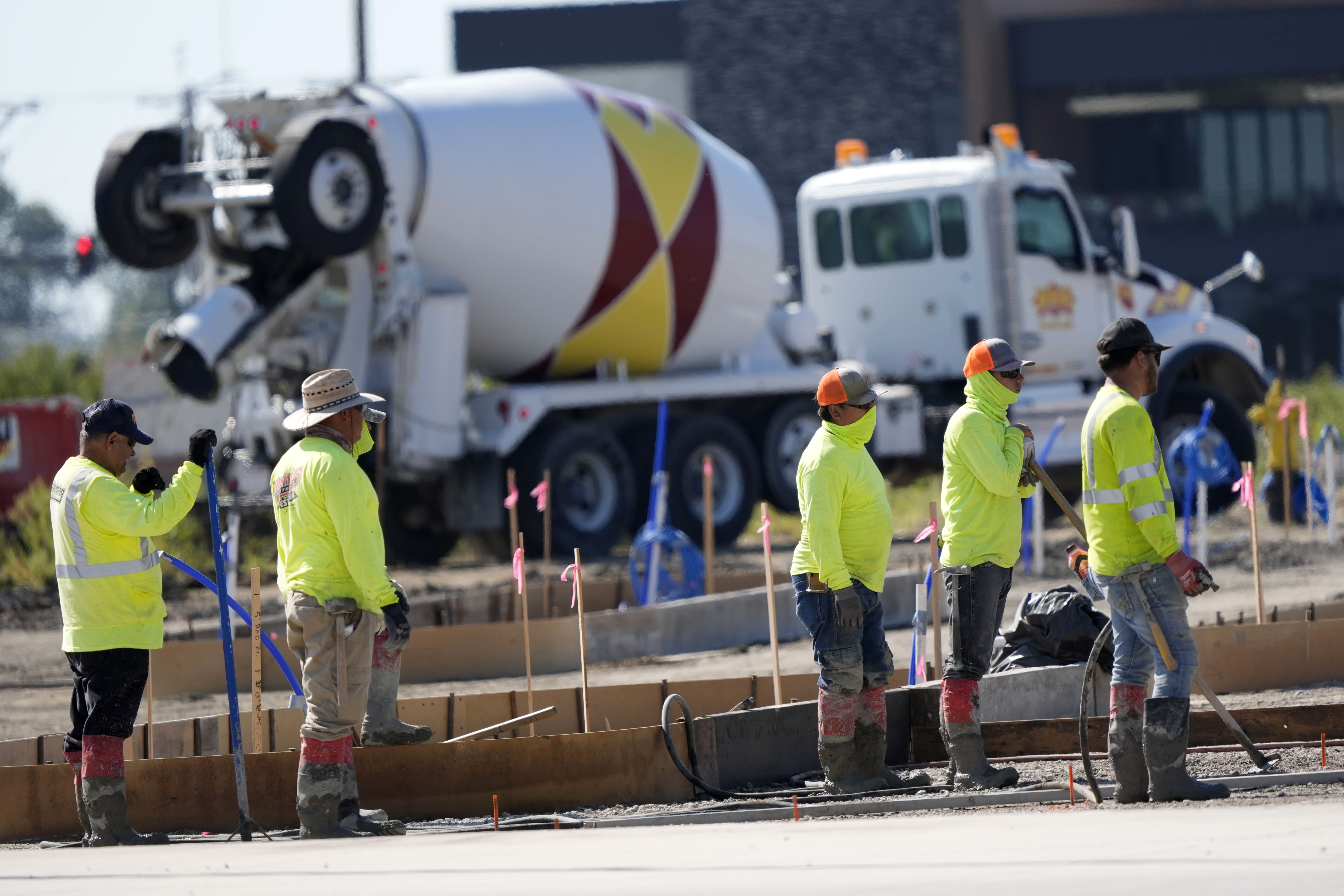 FILE - Construction crew members wait to pour concrete in a parking lot on Sept. 4, 2024, in Waukee, Iowa. (AP Photo/Charlie Neibergall, File)