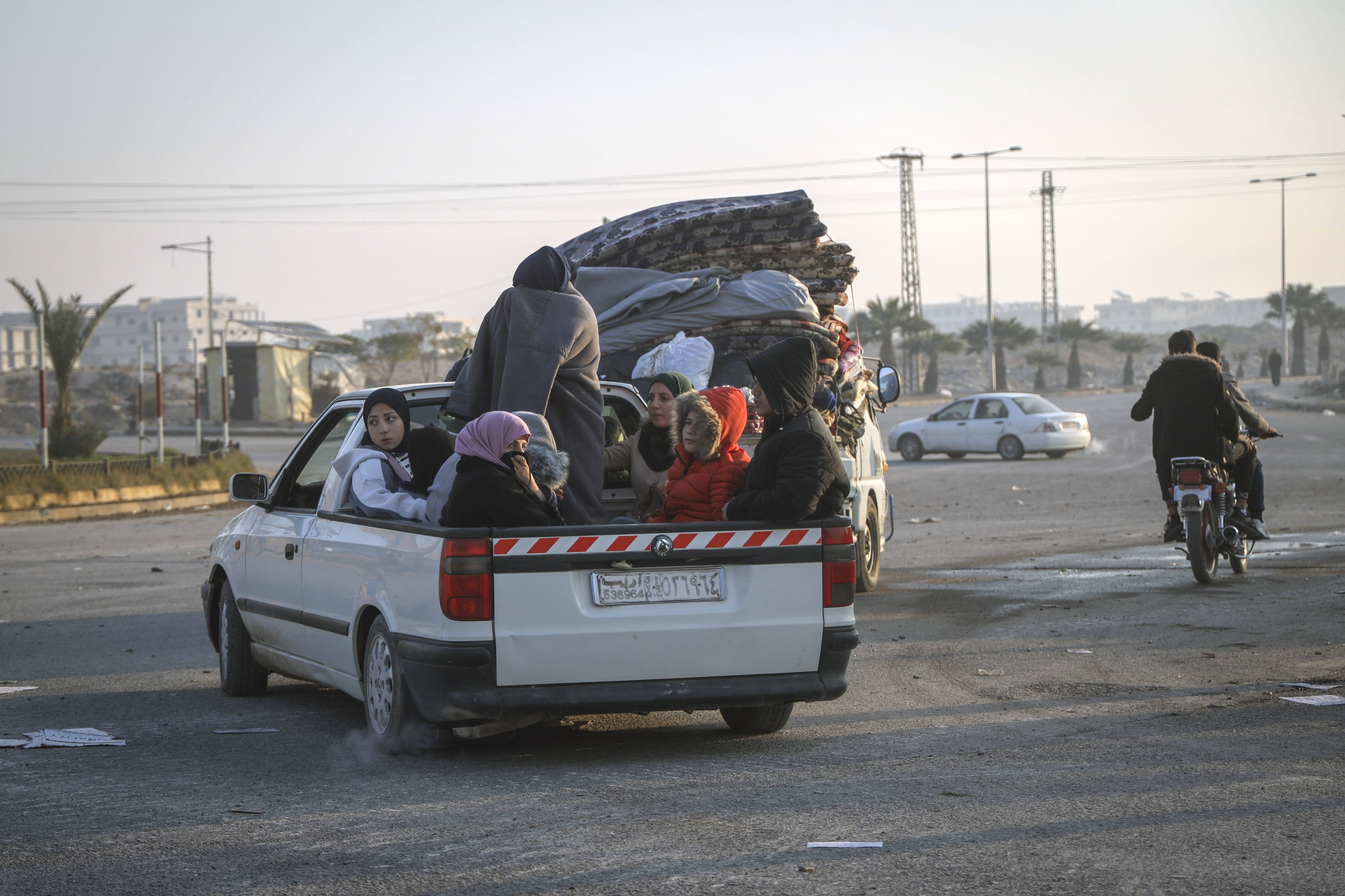 Residents leave the city carrying their belongings in Hama, Syria, Friday Dec. 6, 2024.(AP Photo/Omar Albam)