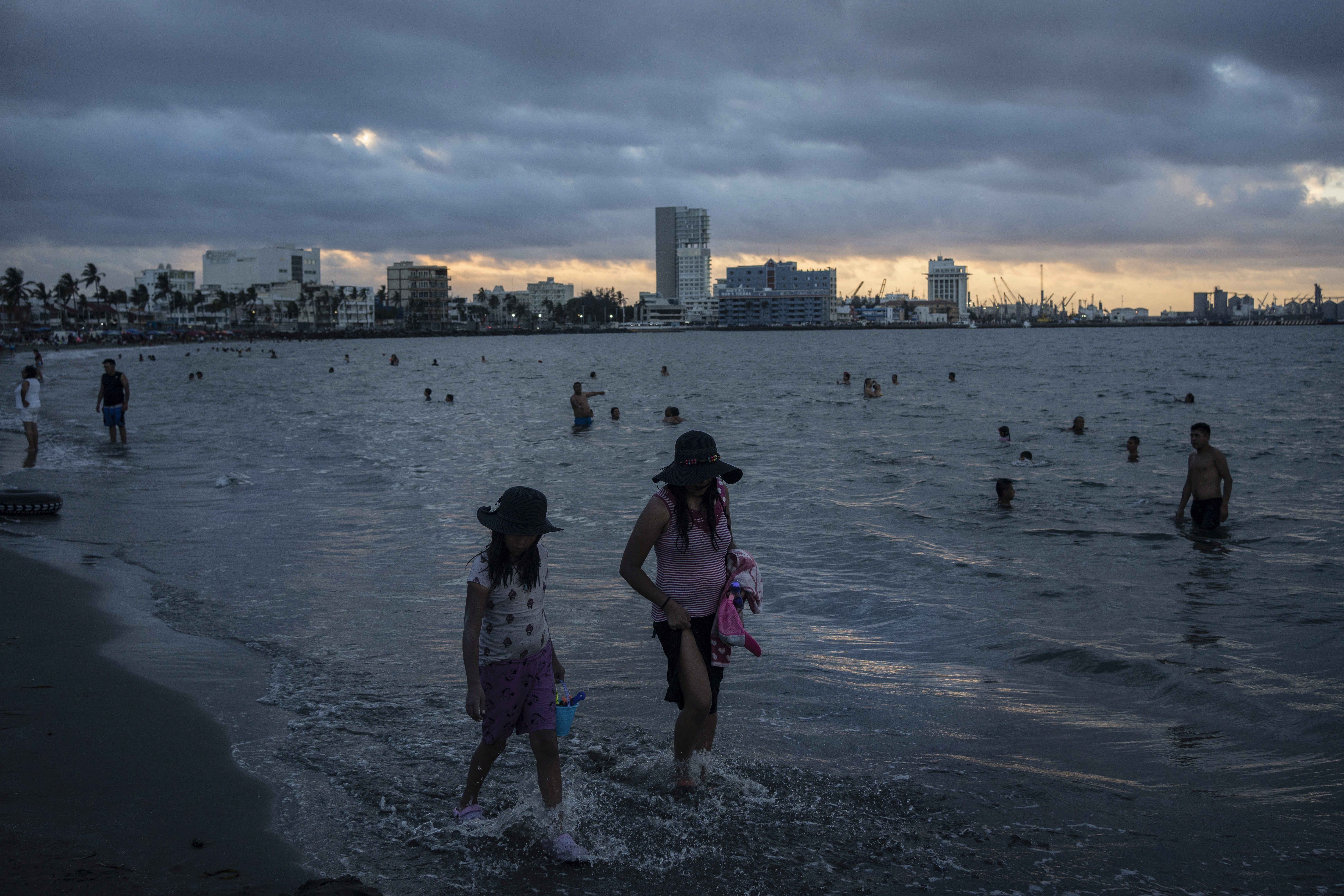 FILE - A woman and a girl walk along the shore to cool off during a heat wave on the coast of Veracruz, Mexico, on June 15, 2024. (AP Photo/Felix Marquez, File)