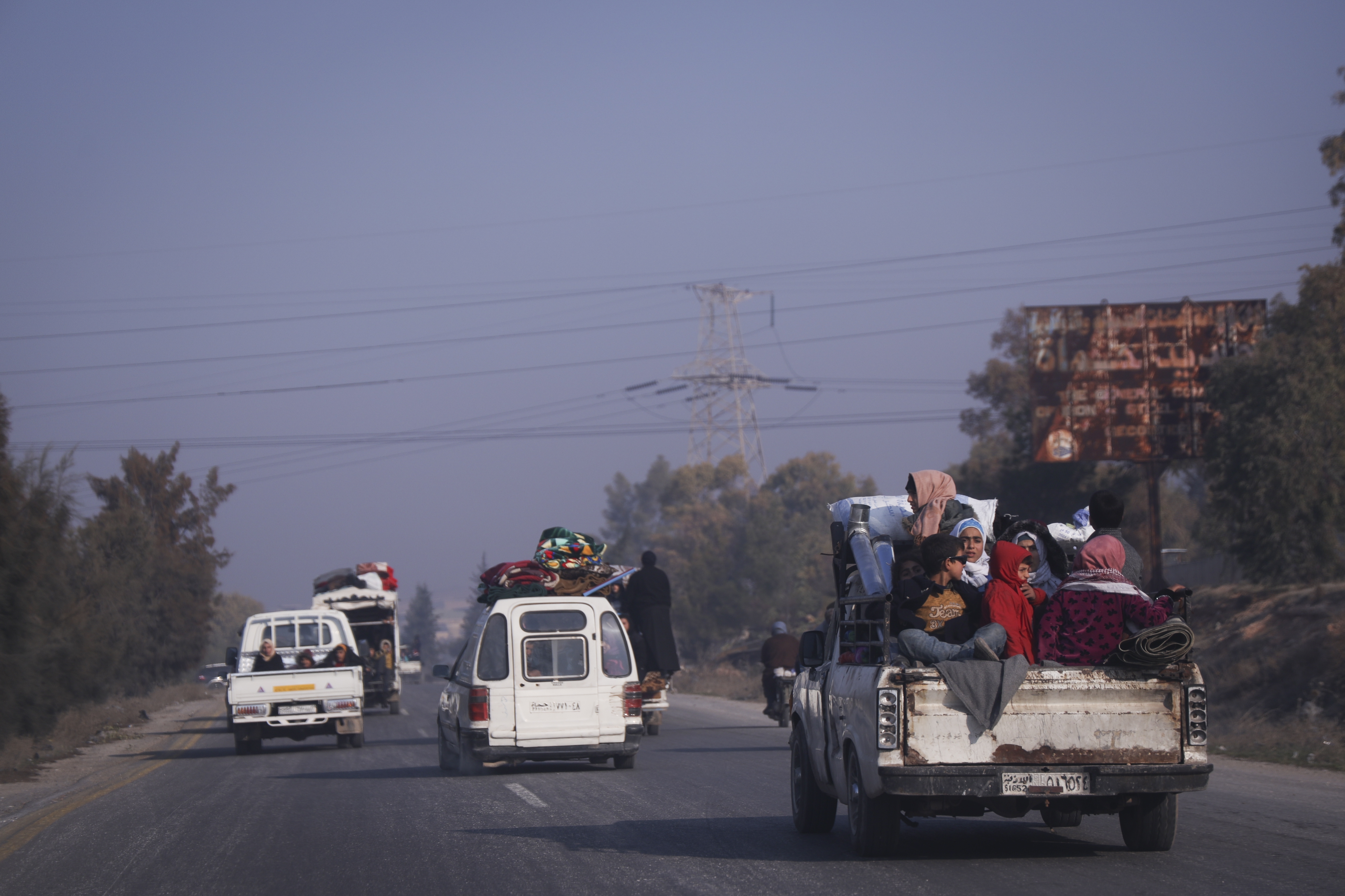 Residents leave the city carrying their belongings in Hama, Syria, Friday Dec. 6, 2024.(AP Photo/Omar Albam)