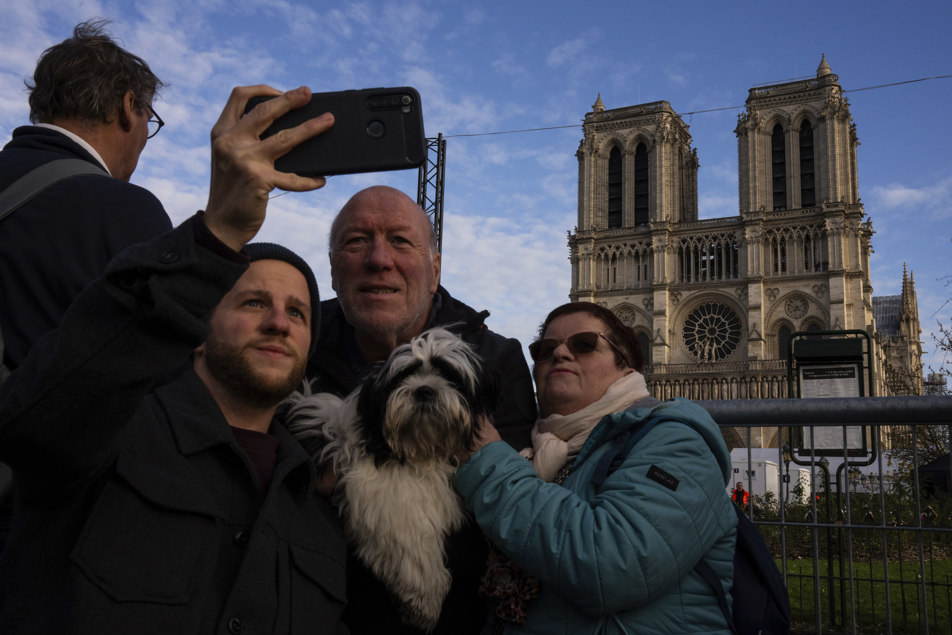 People take photographs of Notre Dame cathedral in Paris, Friday, Dec. 6, 2024. (AP Photo/Louise Delmotte)