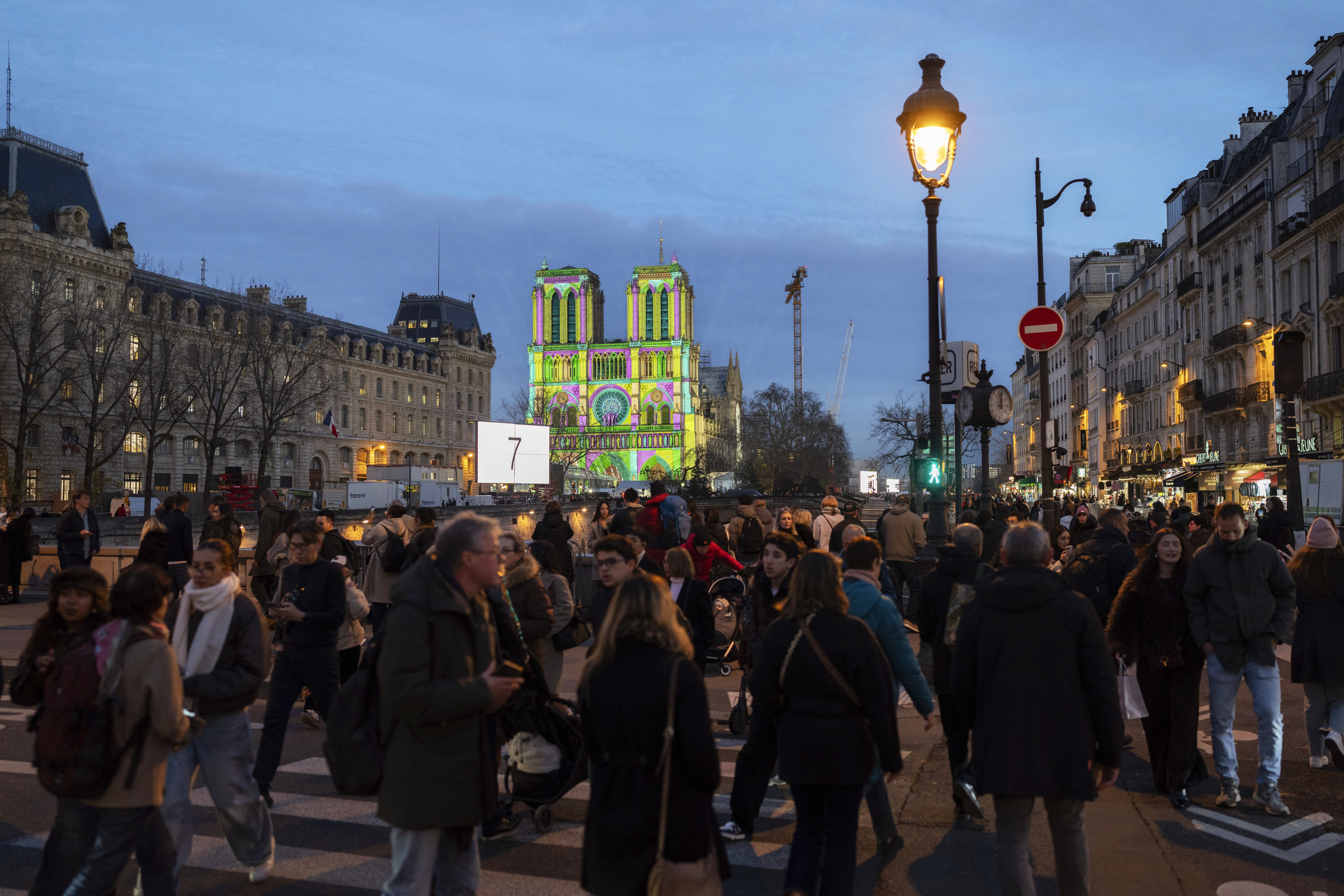 Pedestrians walk past Notre Dame Cathedral a day before its ceremonial reopening in Paris on Friday, Dec. 6, 2024, following the devastating fire of 2019. (AP Photo/Bernat Armangue)