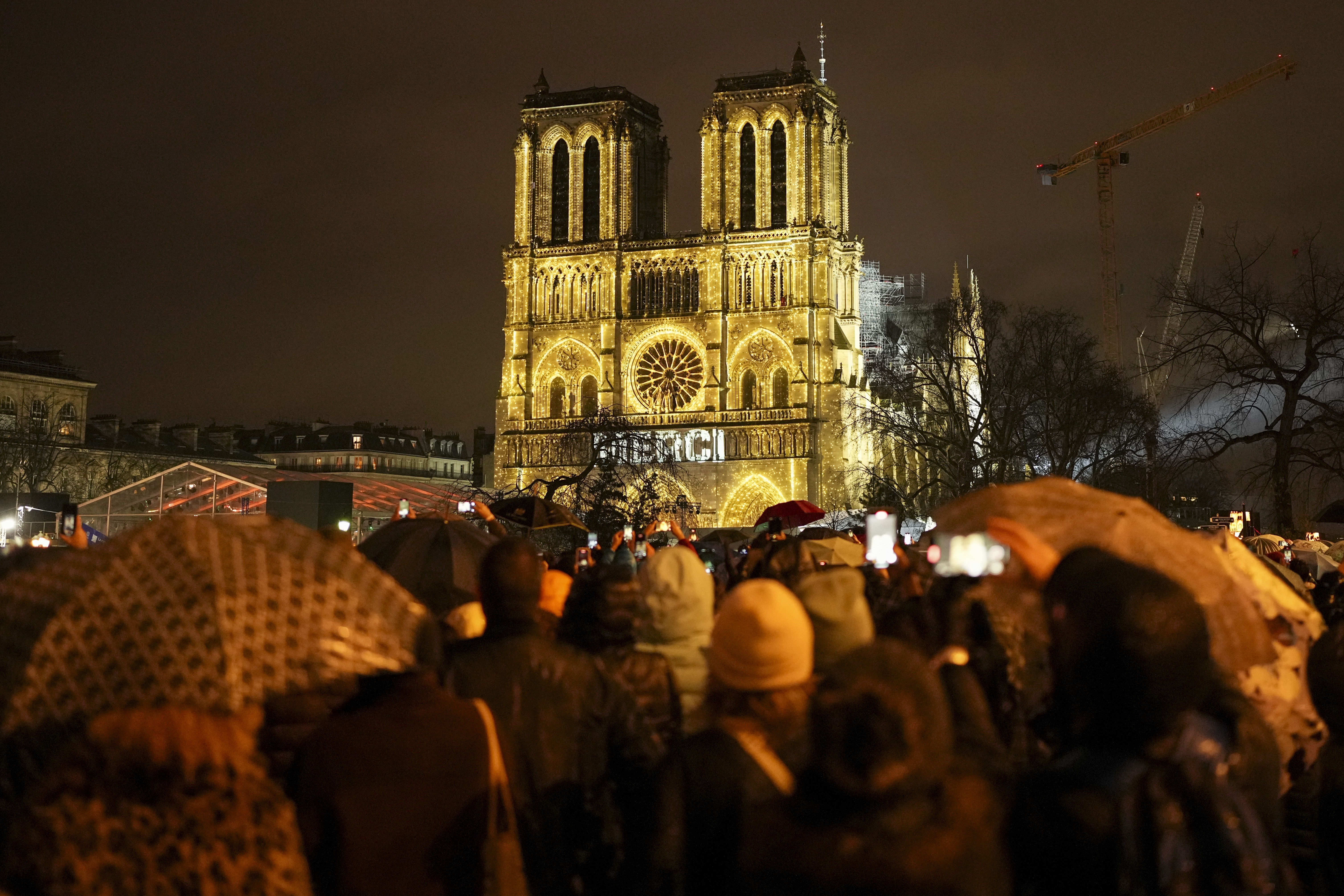 Spectators gather outside France's iconic Notre Dame Cathedral Saturday, Dec. 7, 2024 in Paris for it's formal reopening for the first time since a devastating fire nearly destroyed the 861-year-old landmark in 2019. (AP Photo/Alessandra Tarantino)