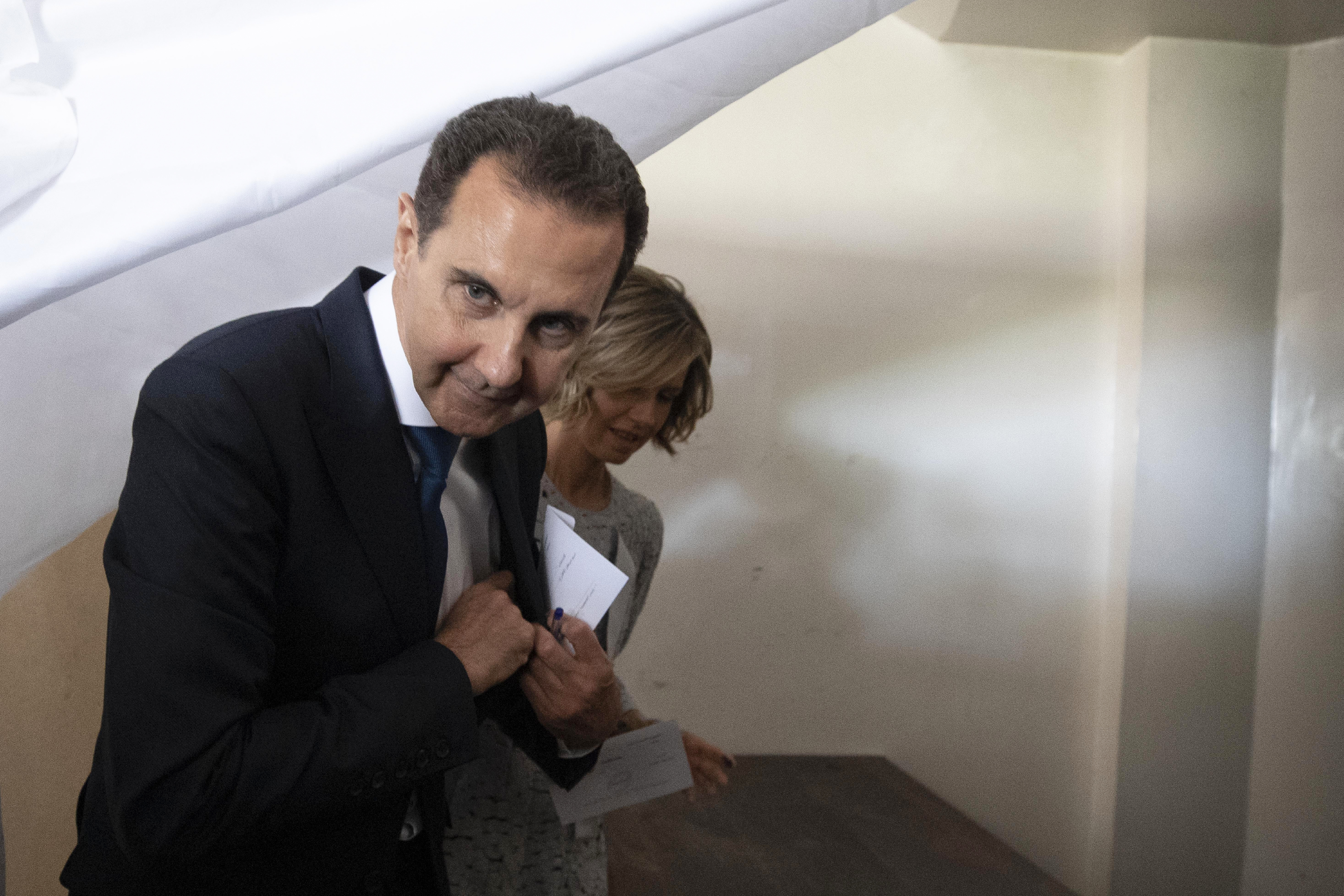 FILE - Syrian President Bashar Assad and his wife Asma prepare to vote at a polling station during the presidential elections in the town of Douma, in the eastern Ghouta region, near the Syrian capital Damascus, Syria, May 26, 2021. (AP Photo/Hassan Ammar, File)