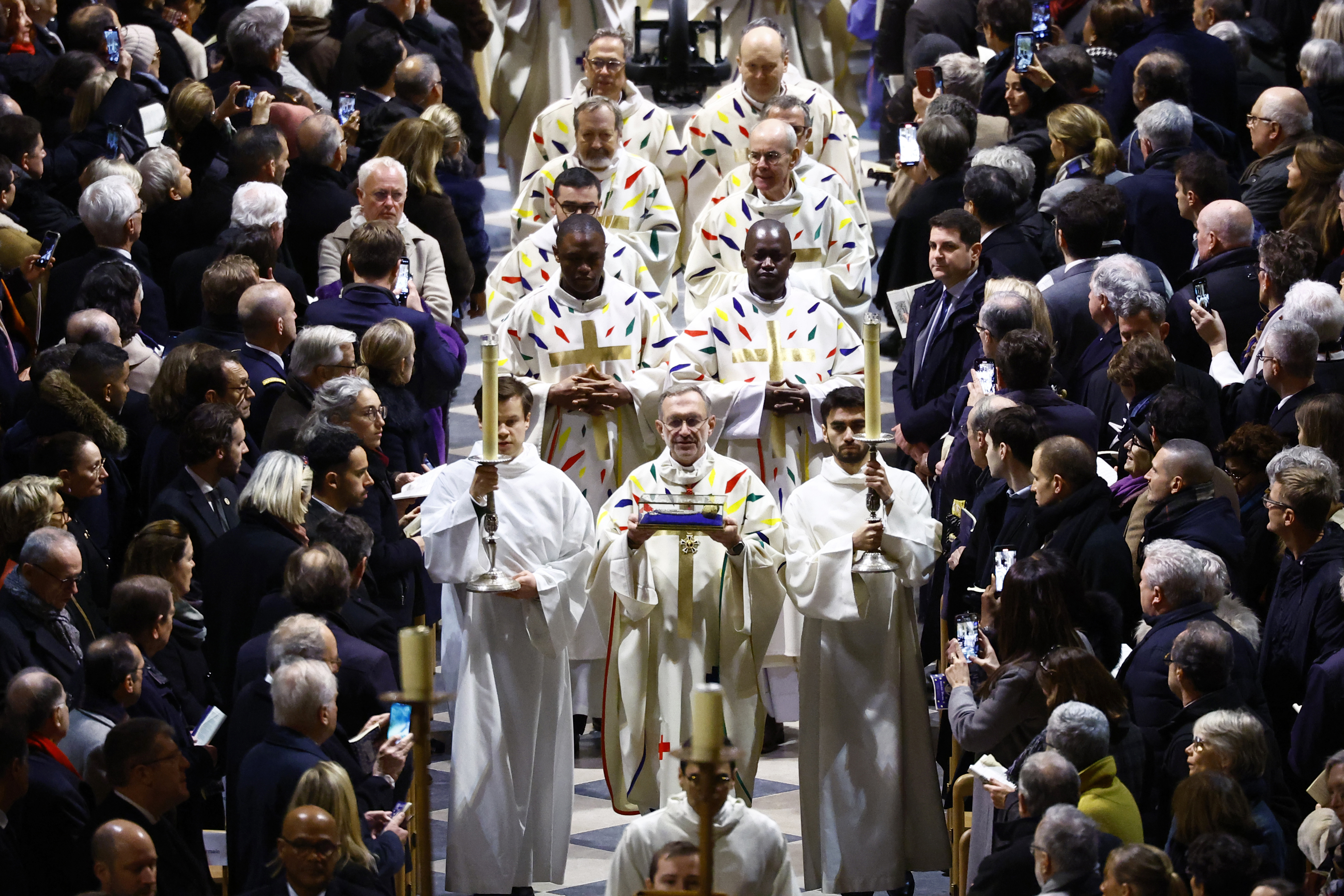 Priests and clergy arrive to attend an inaugural Mass, with the consecration of the high altar, at the Notre-Dame de Paris Cathedral, five-and-a-half years after a fire ravaged the Gothic masterpiece, as part of ceremonies to mark the Cathedral's reopening after its restoration, in Paris, France, Sunday, Dec. 8, 2024. (Sarah Meyssonnier/Pool Photo via AP)