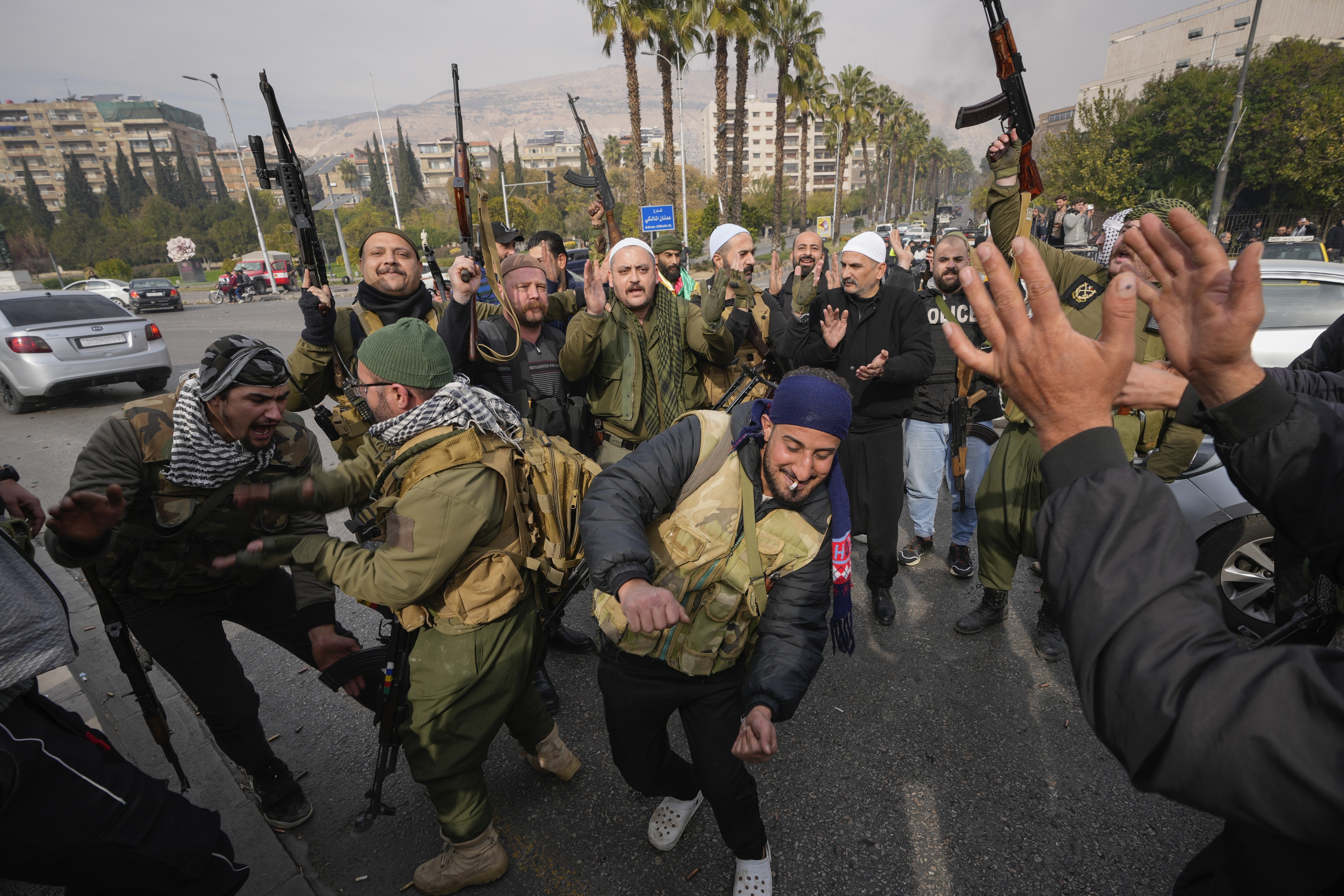 Opposition fighters celebrate in Damascus, Syria, Sunday Dec. 8, 2024. (AP Photo/Hussein Malla)