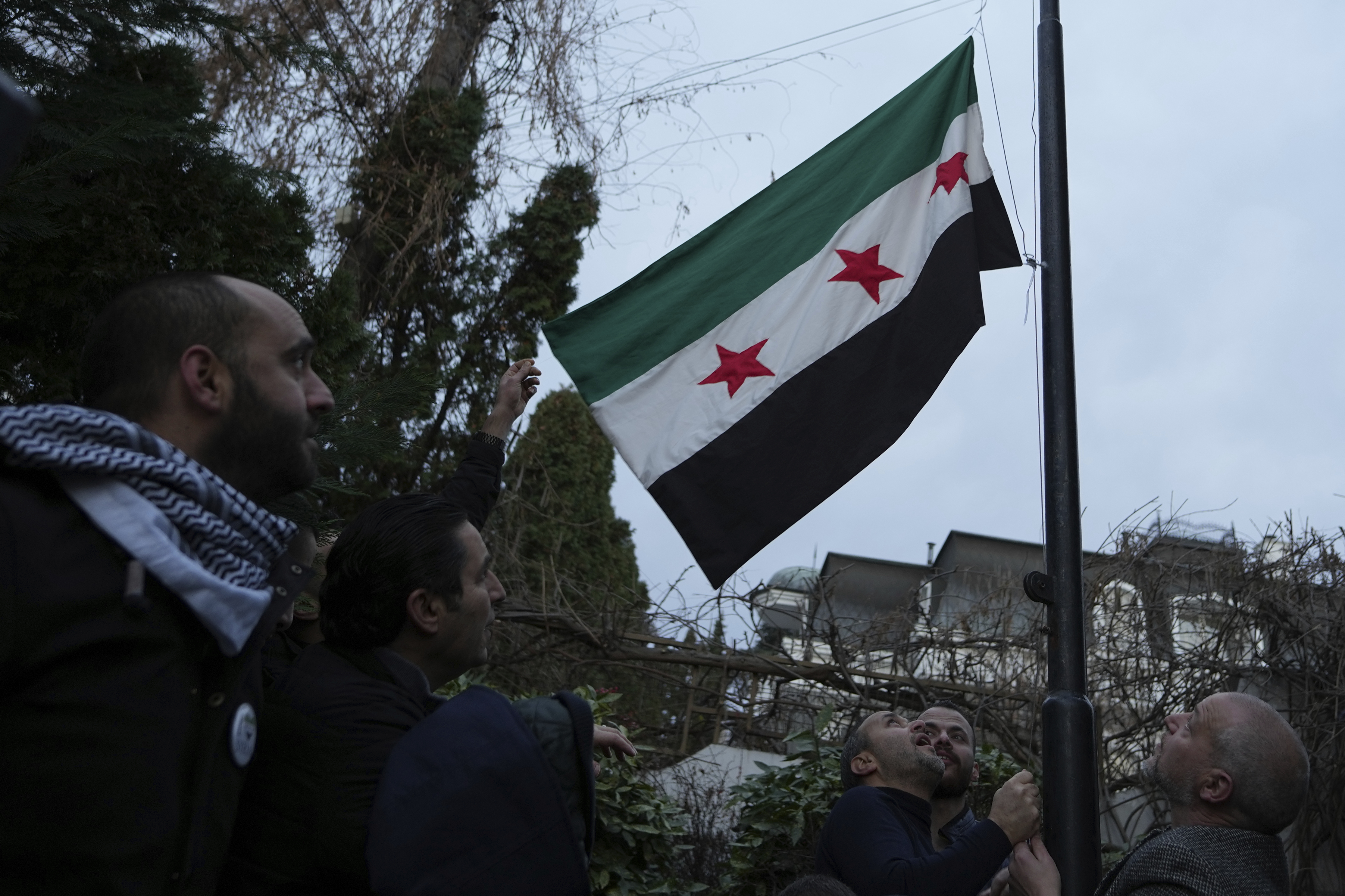 People set a Syrian opposition flag in front of the Syrian embassy in Belgrade, Serbia, Sunday, Dec. 8, 2024. (AP Photo/Darko Vojinovic)