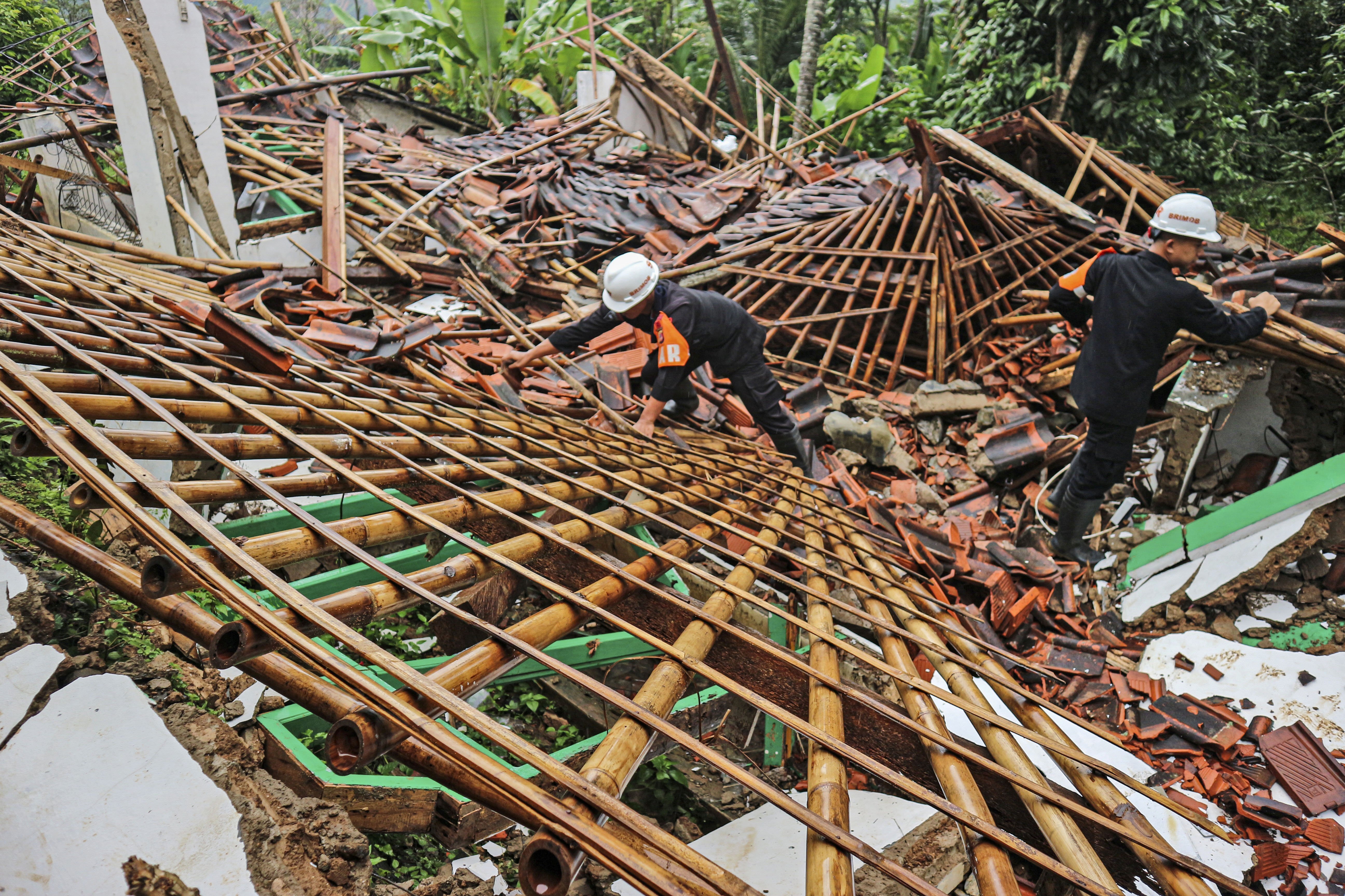 Rescuers clear up rubble from damaged houses at a neighborhood affected by a landslide in Sukabumi, West Java, Indonesia, Monday, Dec. 9, 2024. (AP Photo/Rangga Firmansyah)