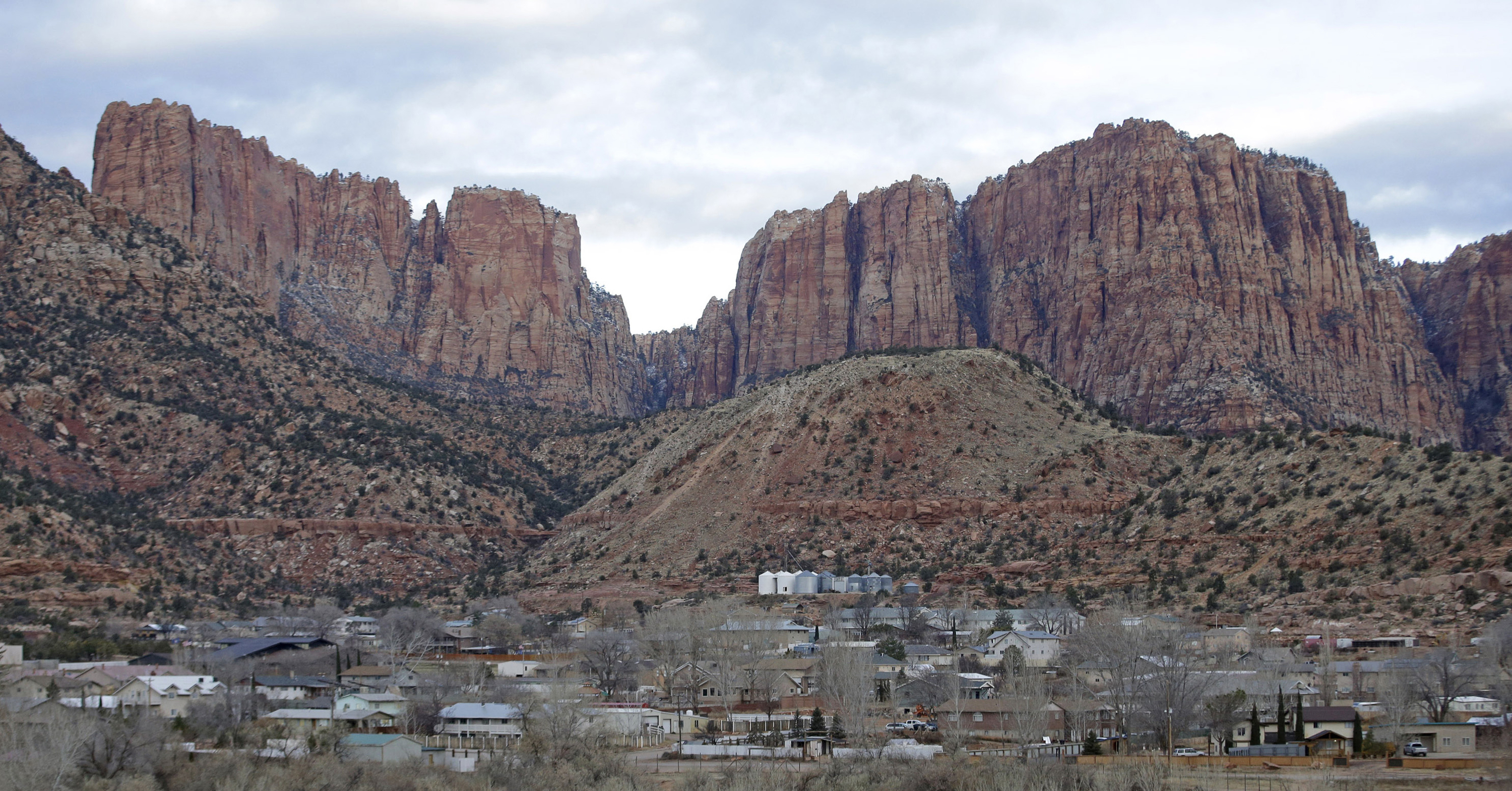 FILE - This photo shows Hildale, Utah, sitting at the base of Red Rock Cliff mountains, with its sister city, Colorado City, Ariz., in the foreground, Dec. 16, 2014. T. (AP Photo/Rick Bowmer, File)