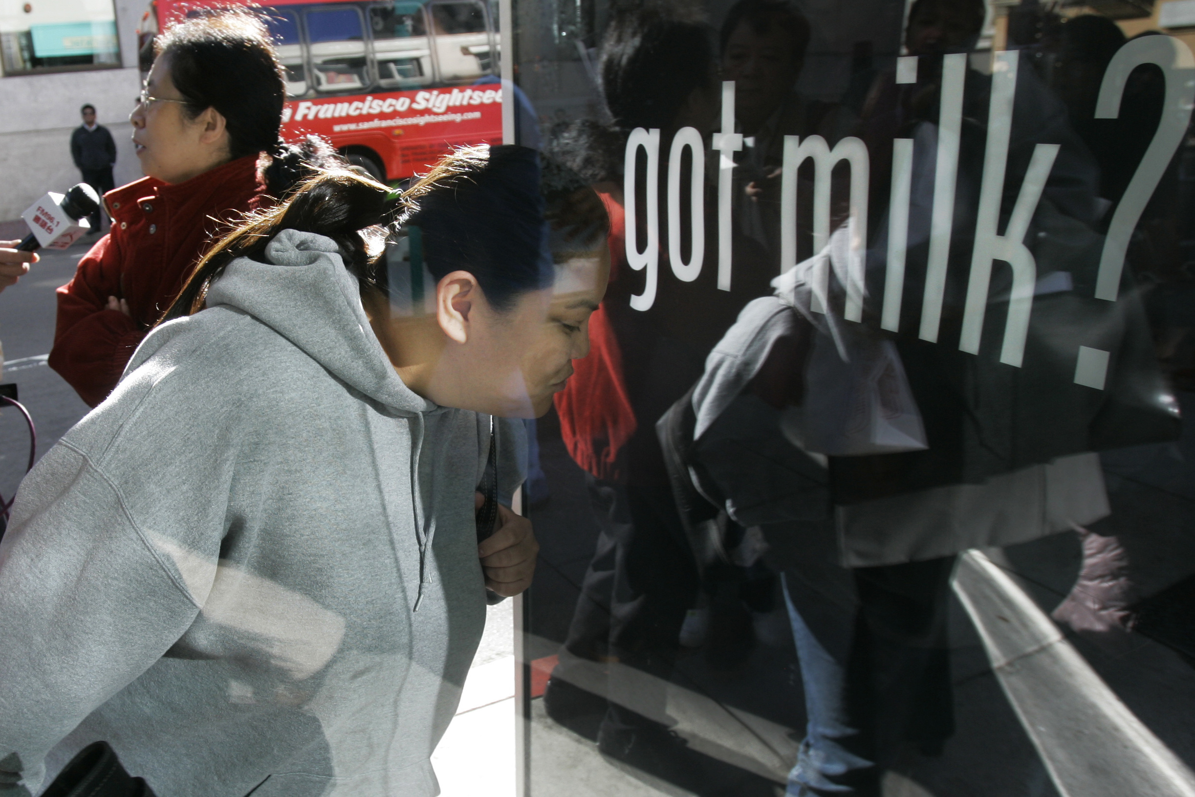 FILE - Ihrene Supapo smells the aroma around the new scented "Got Milk?" advertisement in San Francisco, Monday, Dec. 4, 2006. (AP Photo/Jeff Chiu, File)