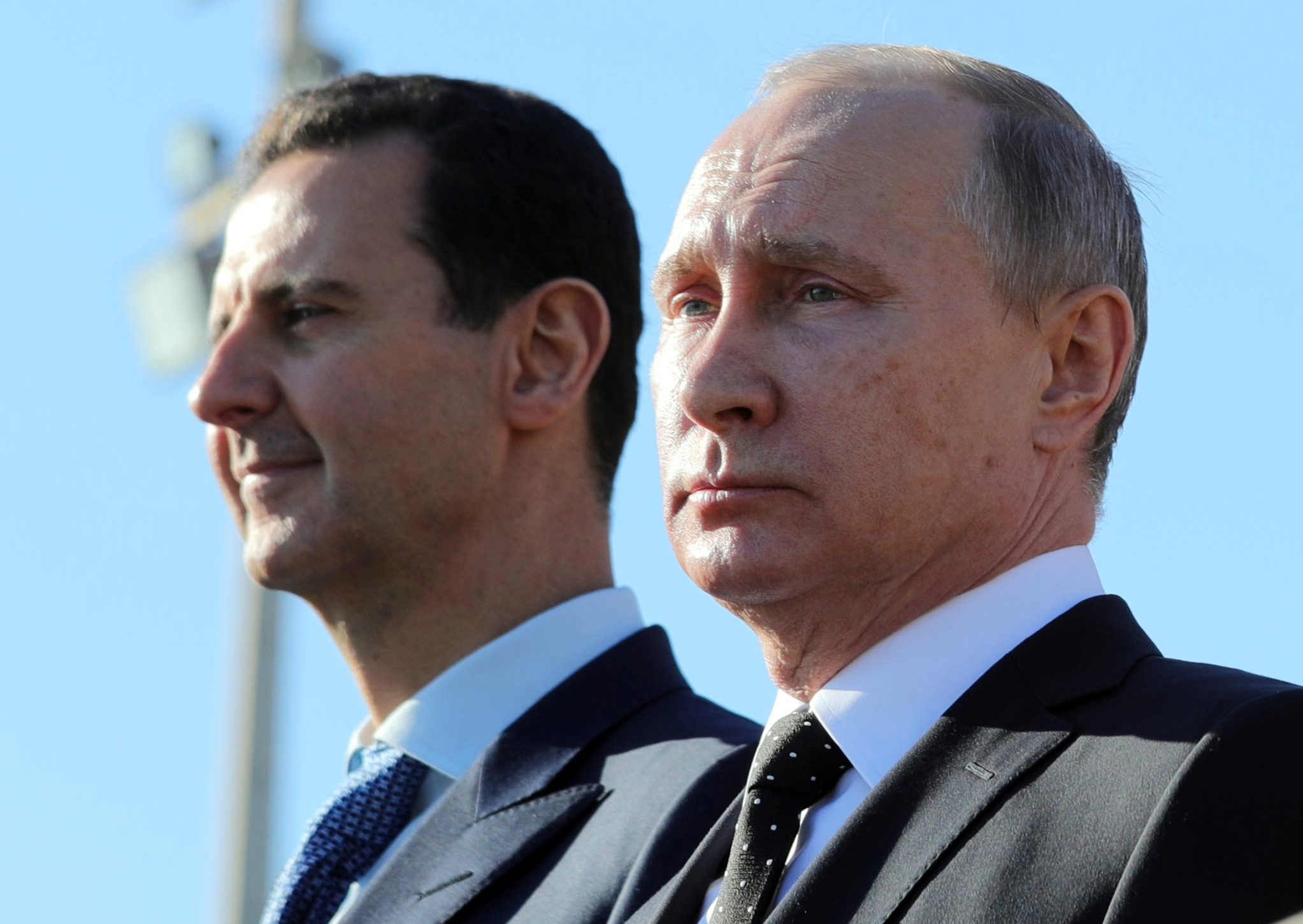 FILE - Russian President Vladimir Putin, right, and Syrian President Bashar Assad watch troops marching at the Hemeimeem air base in Syria, on Dec. 11, 2017. (Mikhail Klimentyev, Sputnik, Kremlin Pool Photo via AP, File)