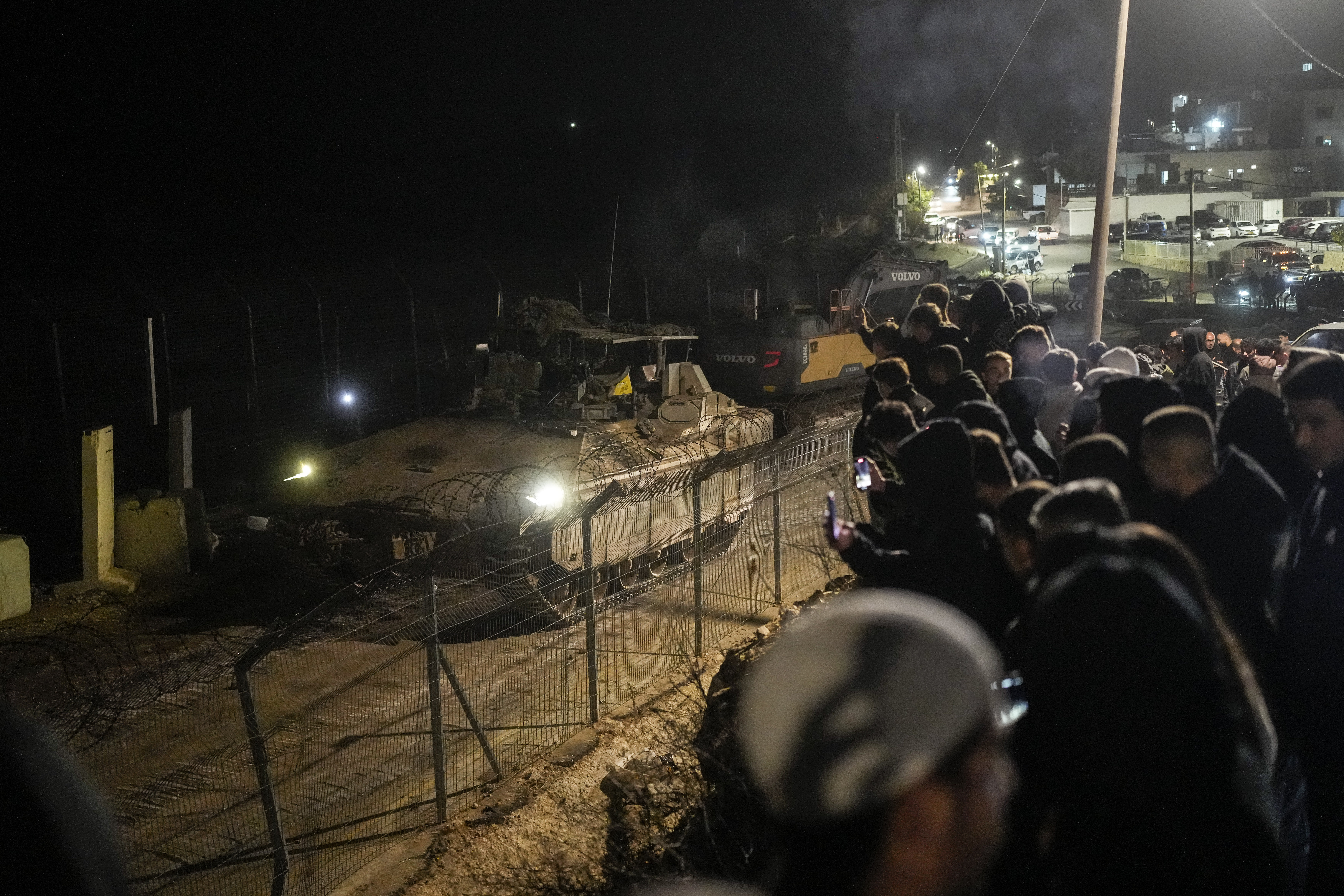 An Israeli armored vehicle maneuvers near the so-called Alpha Line that separates the Israeli-annexed Golan Heights from Syria, in the town of Majdal Shams, Sunday, Dec. 8, 2024. (AP Photo/Matias Delacroix)