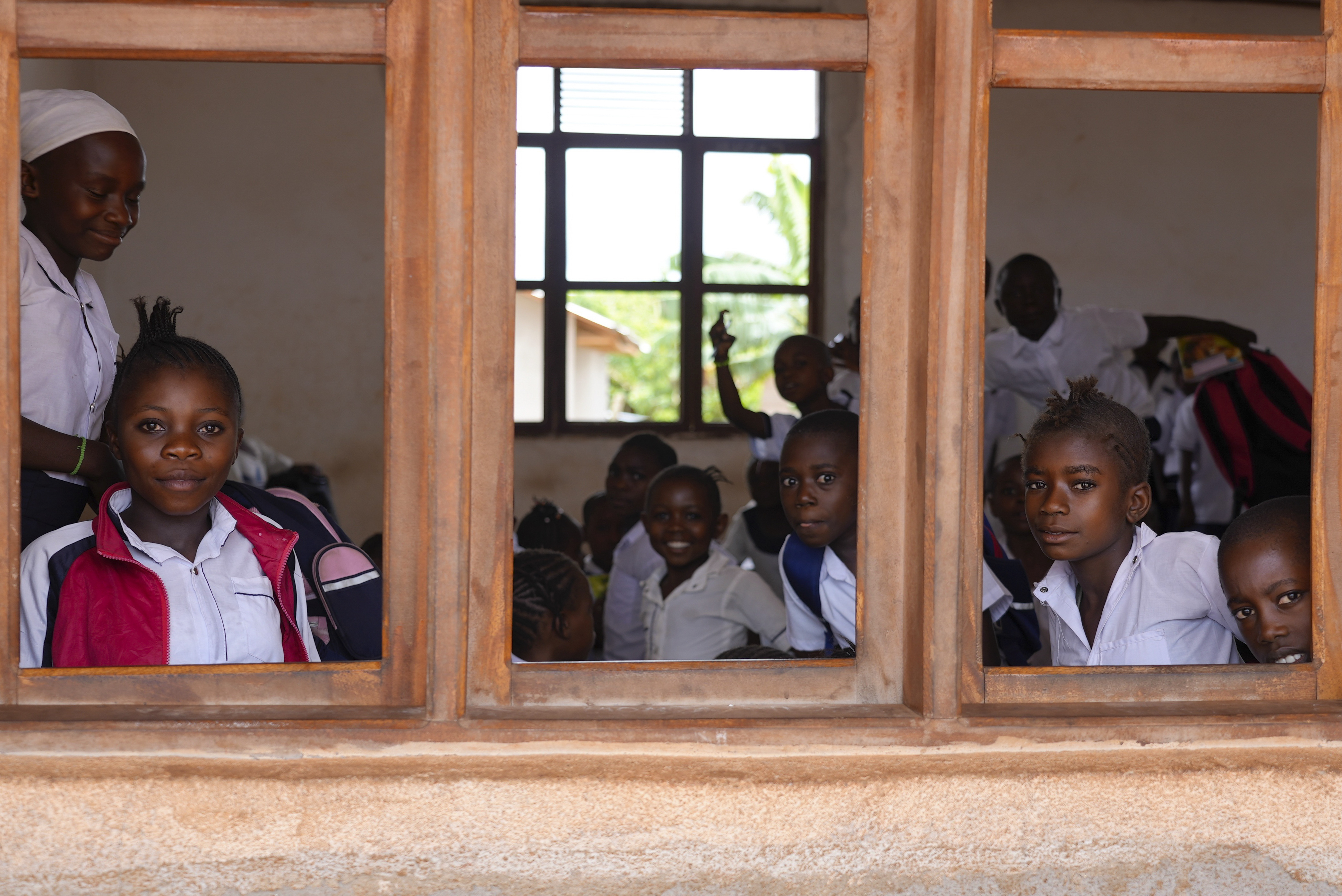 Children sit in a classroom with no windowpanes, built by a Chinese mining company, Kimia Mining, in Badengaido town in Congo, Sept. 23, 2024. (AP Photo/Sam Mednick)