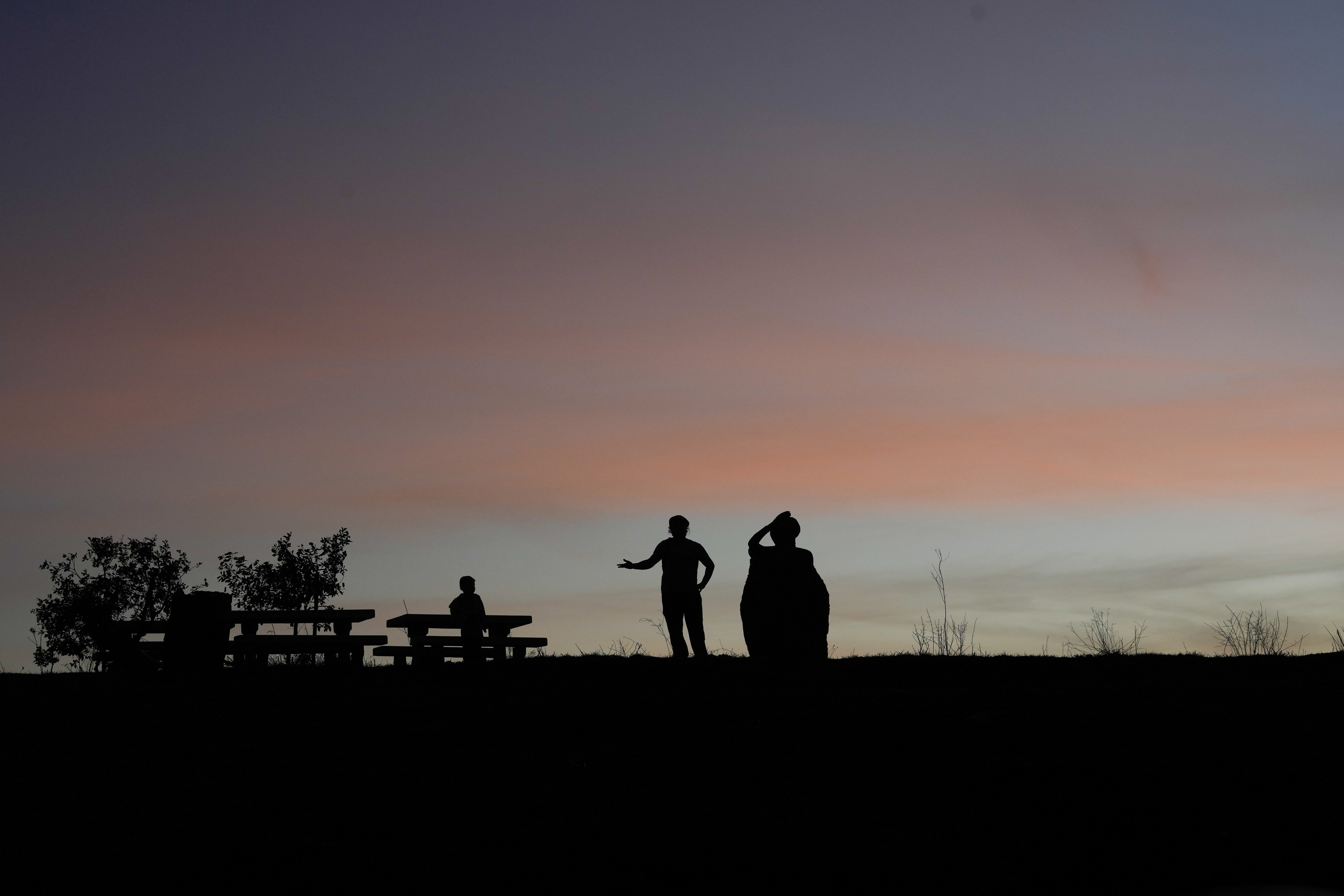 People watch the sunset on Mt Bental near the so-called Alpha Line that separates the Israeli-annexed Golan Heights from Syria, Monday, Dec. 9, 2024. (AP Photo/Matias Delacroix)