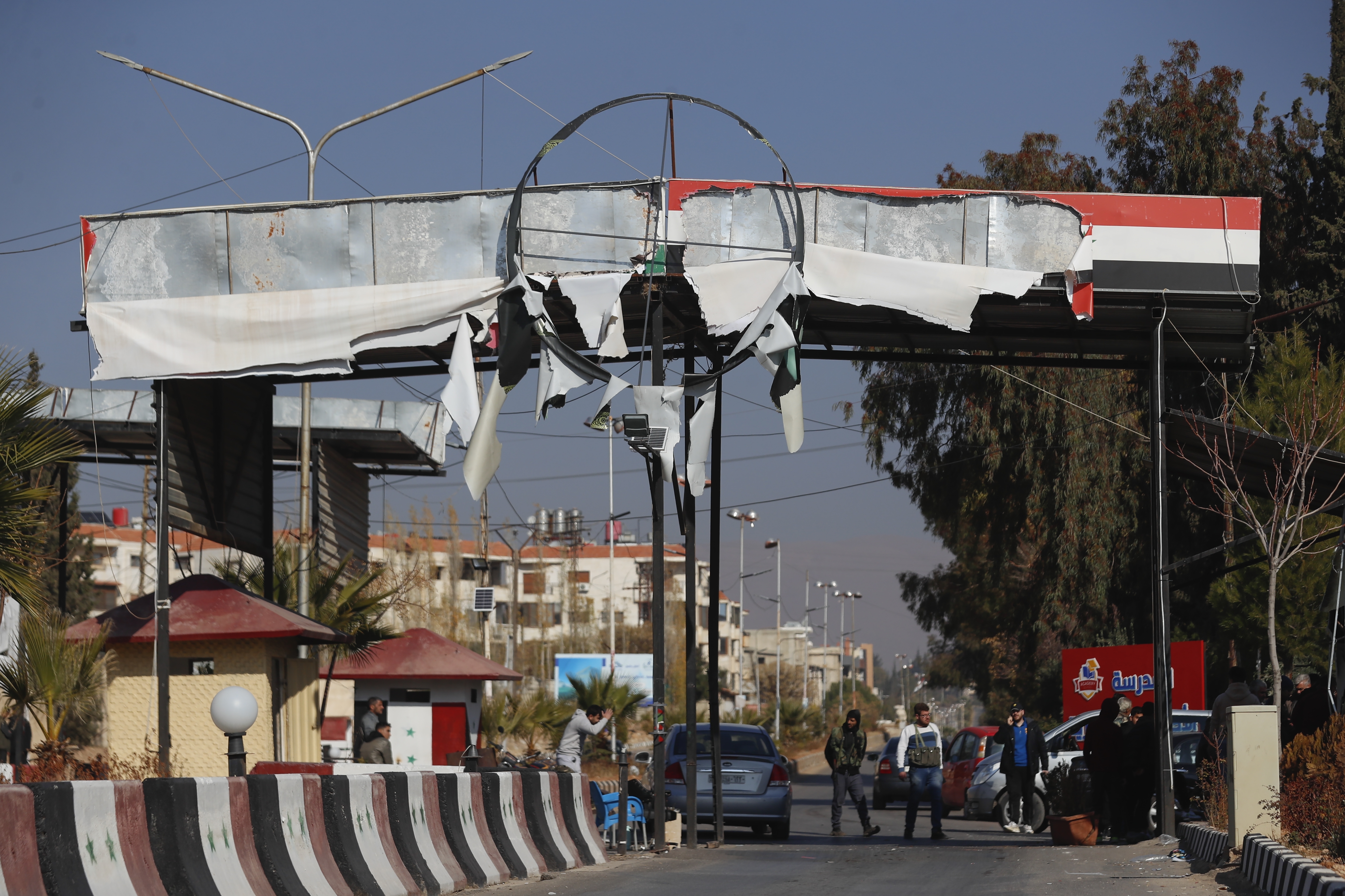 Syrian opposition fighters man a checkpoint in Damascus, Syria, Monday Dec. 9, 2024. (AP Photo/Omar Sanadiki)