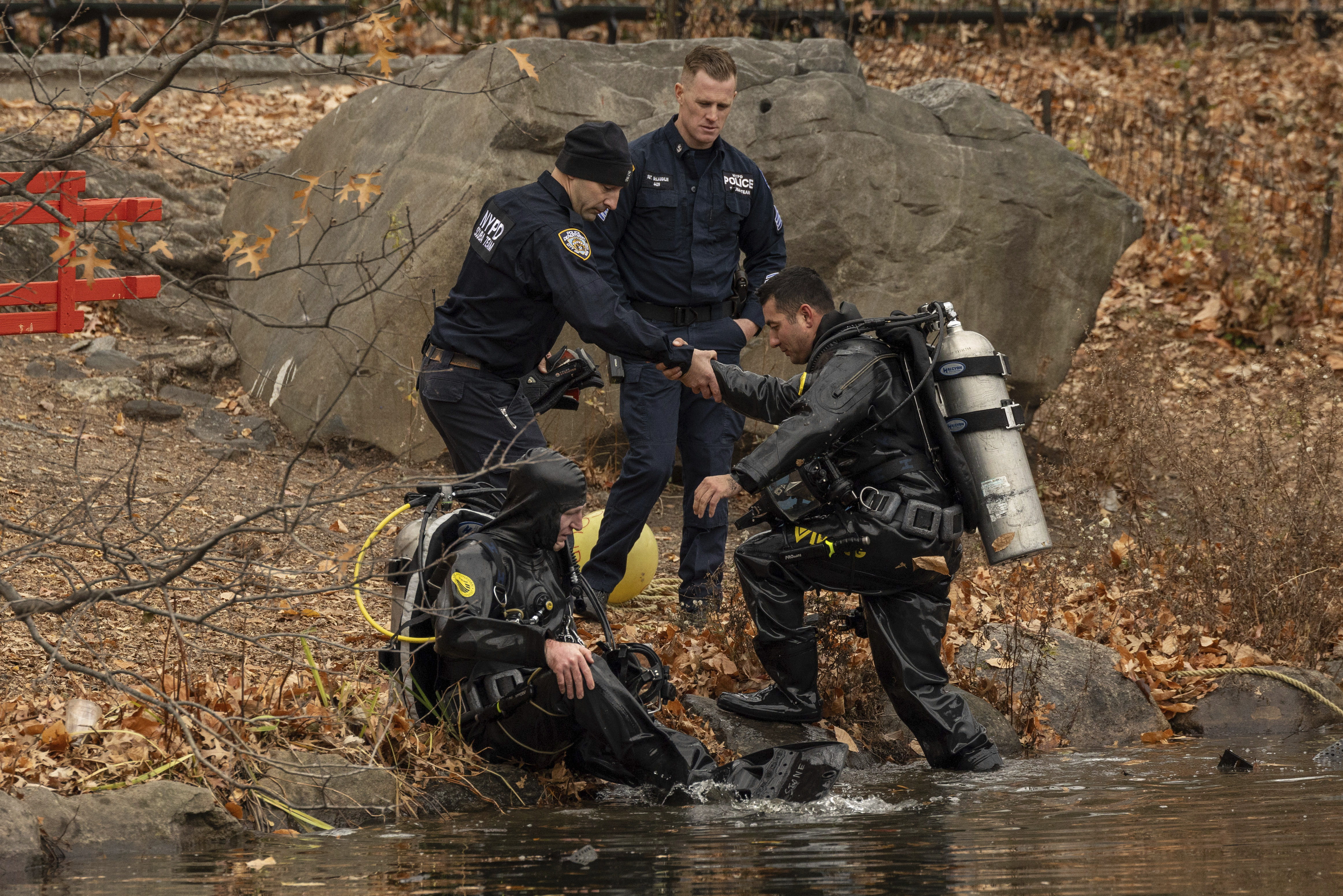 NYPD officers in diving suits sit after searching the lake in the Central Park, Monday, Dec. 9, 2024, in New York. (AP Photo/Yuki Iwamura)