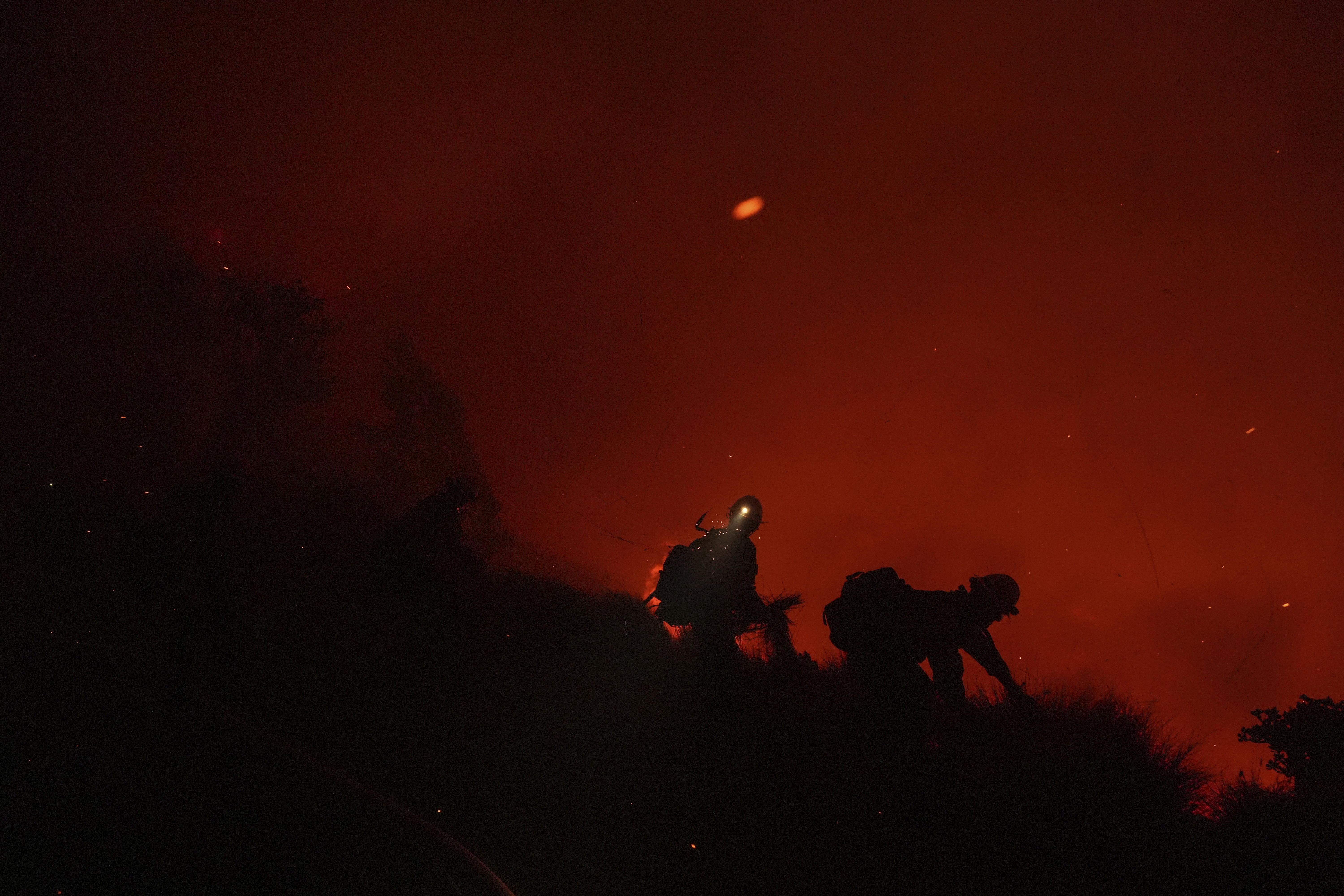 Firefighters remove fuel around the faculty and staff residences at Pepperdine University as the Franklin Fire approaches in Malibu, Calif., Tuesday, Dec. 10, 2024. (AP Photo/Jae C. Hong)