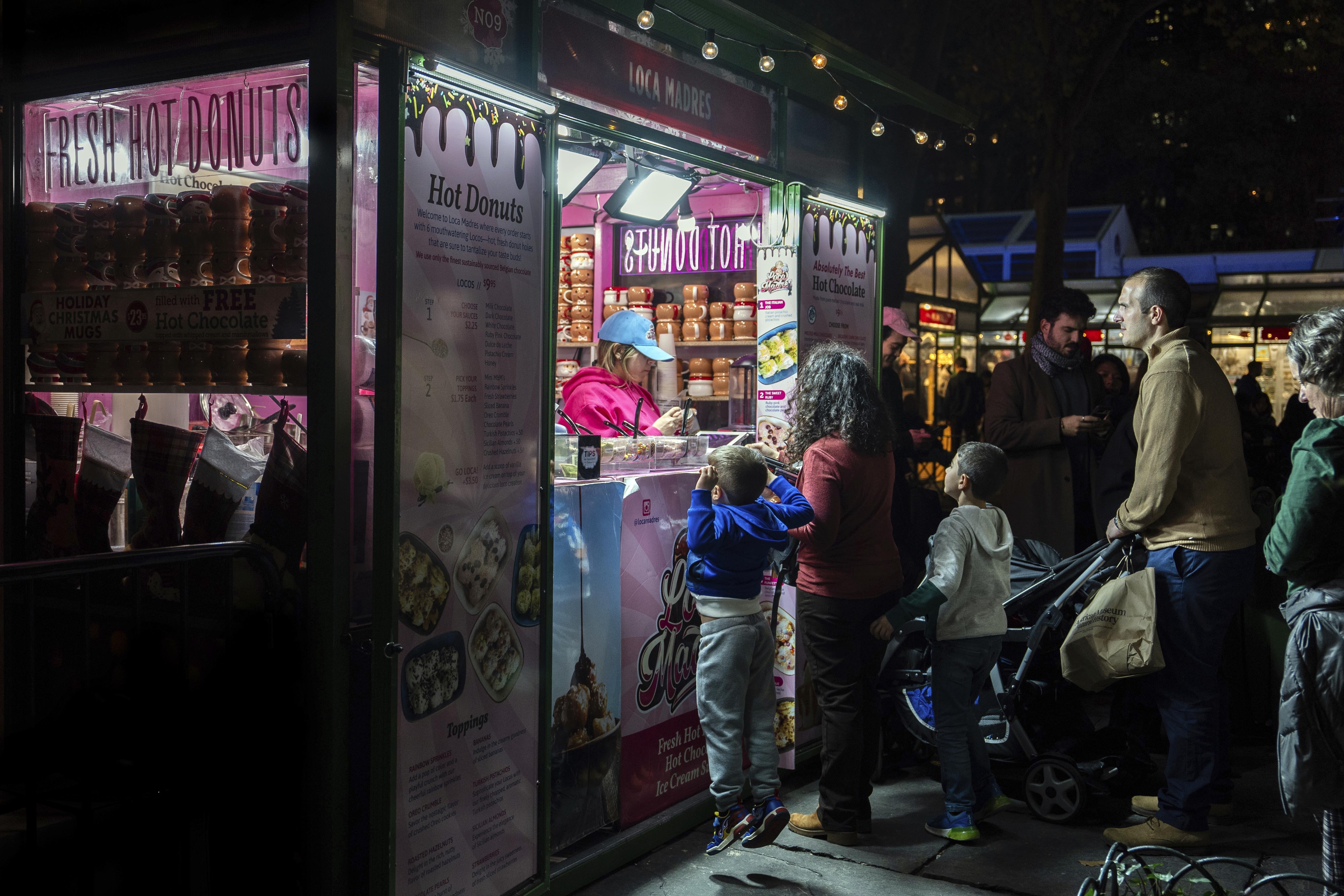 FILE - People wait in line for hot donuts at Bryant Park's Winter Village, Tuesday, Nov. 26, 2024, New York. (AP Photo/Julia Demaree Nikhinson, File)