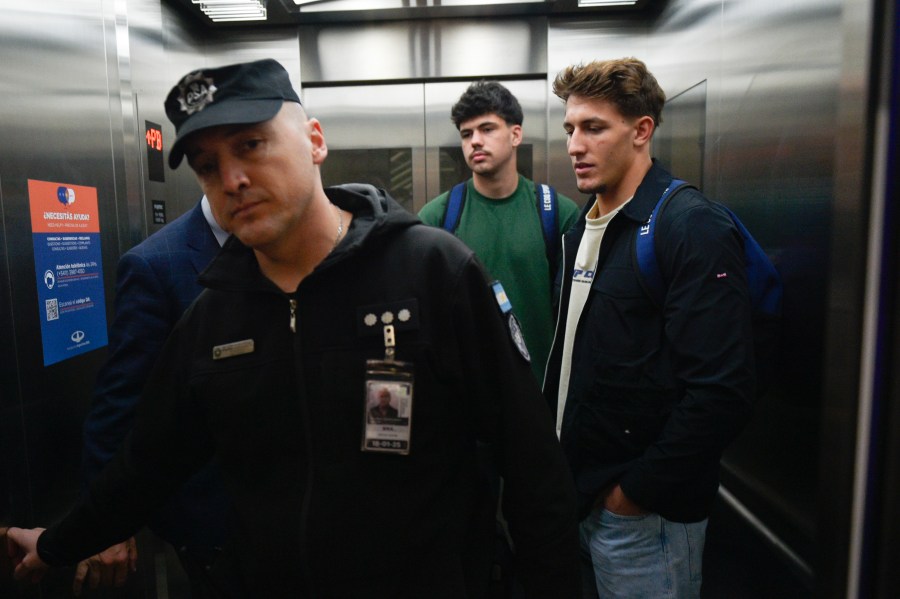 FILE - French rugby players Oscar Jegou, right, and Hugo Auradou, center, stand inside an elevator at the airport in Buenos Aires, Argentina, Sept. 3, 2024, after prosecutors decided to let the player leave the country despite remaining under investigation for alleged rape. (AP Photo/Gustavo Garello, File)