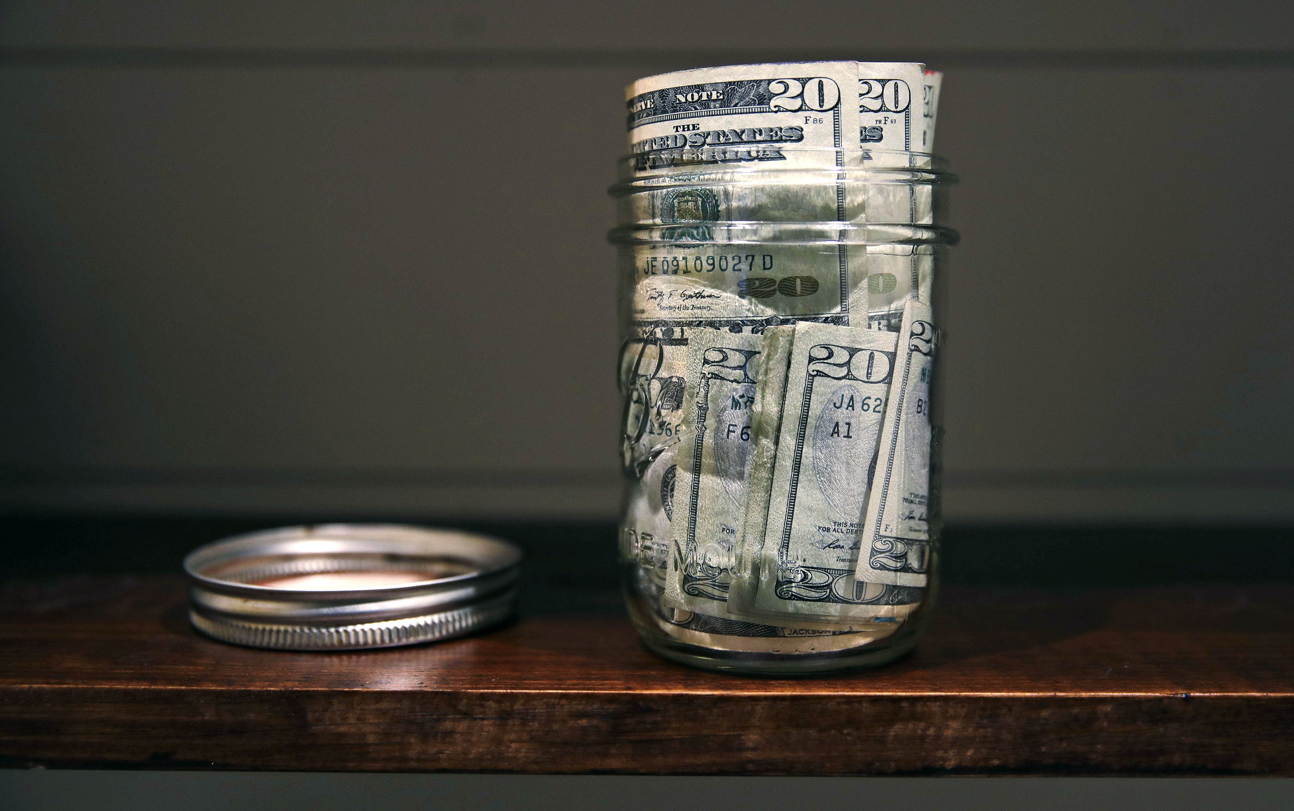 FILE - A canning jar filled with money sits on a shelf in East Derry, N.H., June 15, 2018. (AP Photo/Charles Krupa, File)