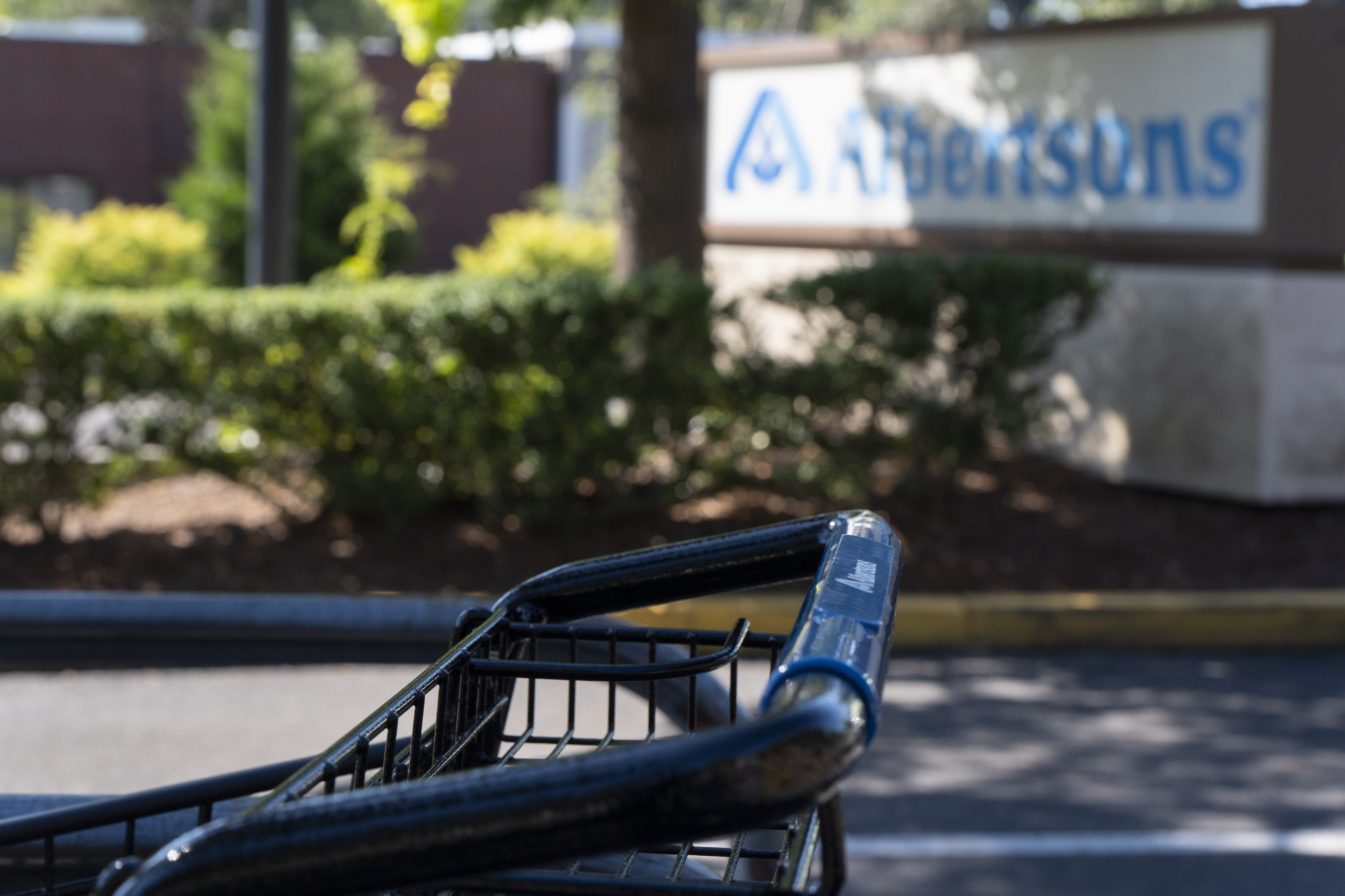 FILE - A grocery cart rests in a cart return area with a sign for Albertsons grocery store in the background on Aug. 26, 2024, in Lake Oswego, Ore. (AP Photo/Jenny Kane, File)