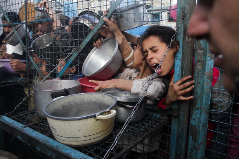 FILE - Palestinians line up to receive free meals at Jabaliya refugee camp in the Gaza Strip on March 18, 2024. (AP Photo/Mahmoud Essa, File)