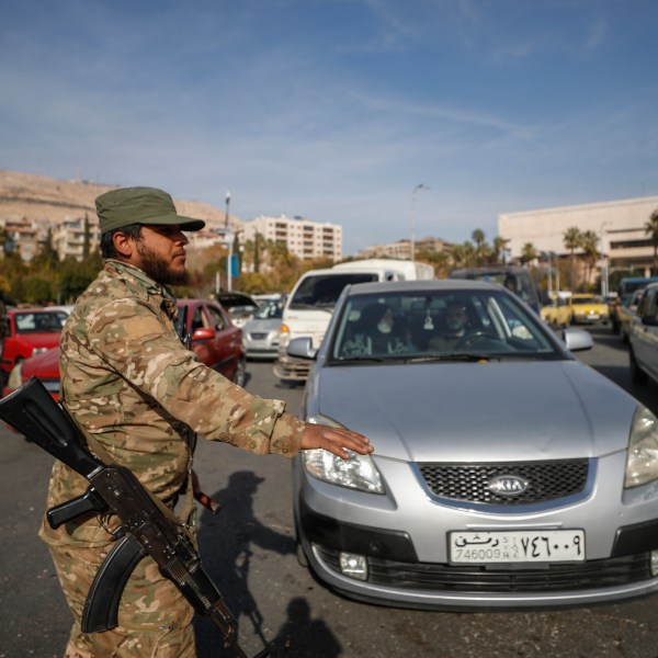 Syrian opposition fighters direct traffic in Damascus, Syria, Tuesday, Dec. 10, 2024. (AP Photo/Omar Sanadiki)