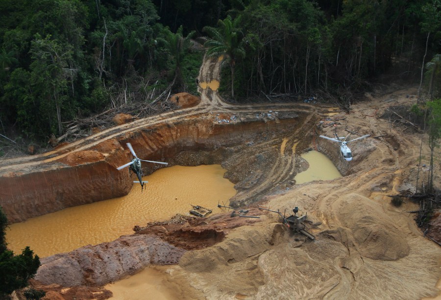 FILE - Brazil Environmental Agency helicopters fly over an illegal mining camp during an operation to try to contain the practice in Yanomami Indigenous territory, Roraima state, Brazil, Feb. 11, 2023. (AP Photo/Edmar Barros, File)