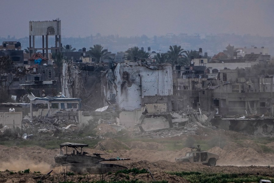 FILE - Israeli soldiers operate inside the Gaza Strip, as seen from southern Israel, Feb. 13, 2024. (AP Photo/Ariel Schalit, File)