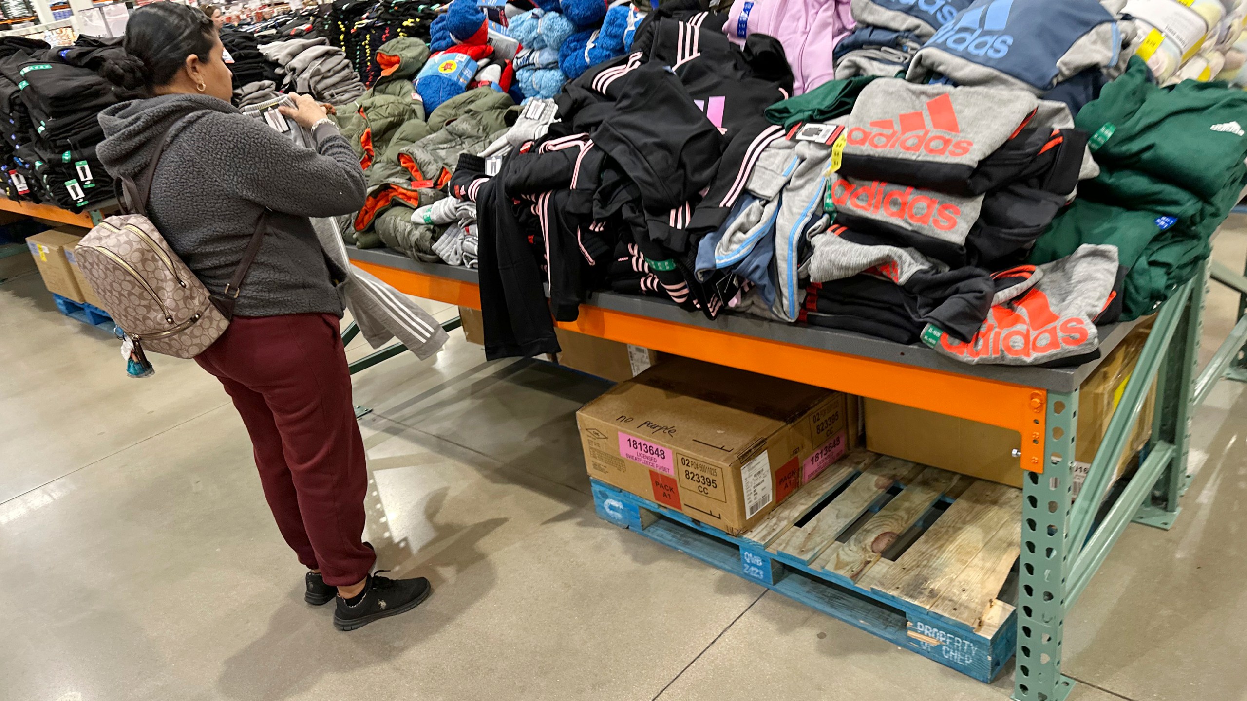 A shopper looks over clothing on display in a Costco warehouse Wednesday, Dec. 4, 2024, in Sheridan, Colo. (AP Photo/David Zalubowski)