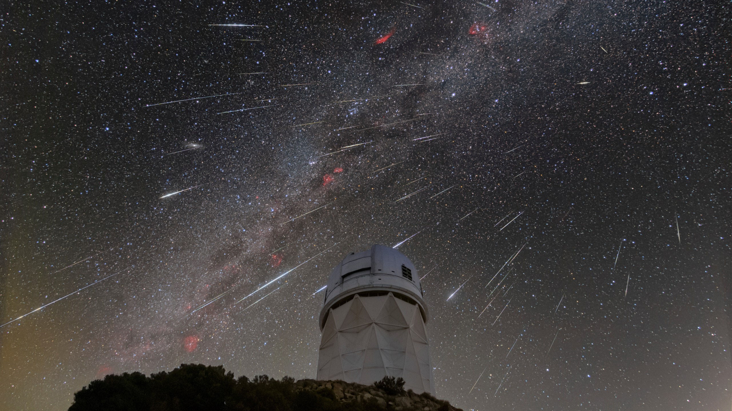 FILE - In this Dec. 14, 2023 photo provided by NOIRLab, meteors from the Geminid meteor shower streak across the sky above the Nicholas U. Mayall Telescope at Kitt Peak National Observatory (KPNO), a program of the National Science Foundation's NOIRLab, located about 56 miles (90 kilometers) southwest of Tucson in the Tohono O'odham Nation. (NSF/NOIRLab via AP, File)