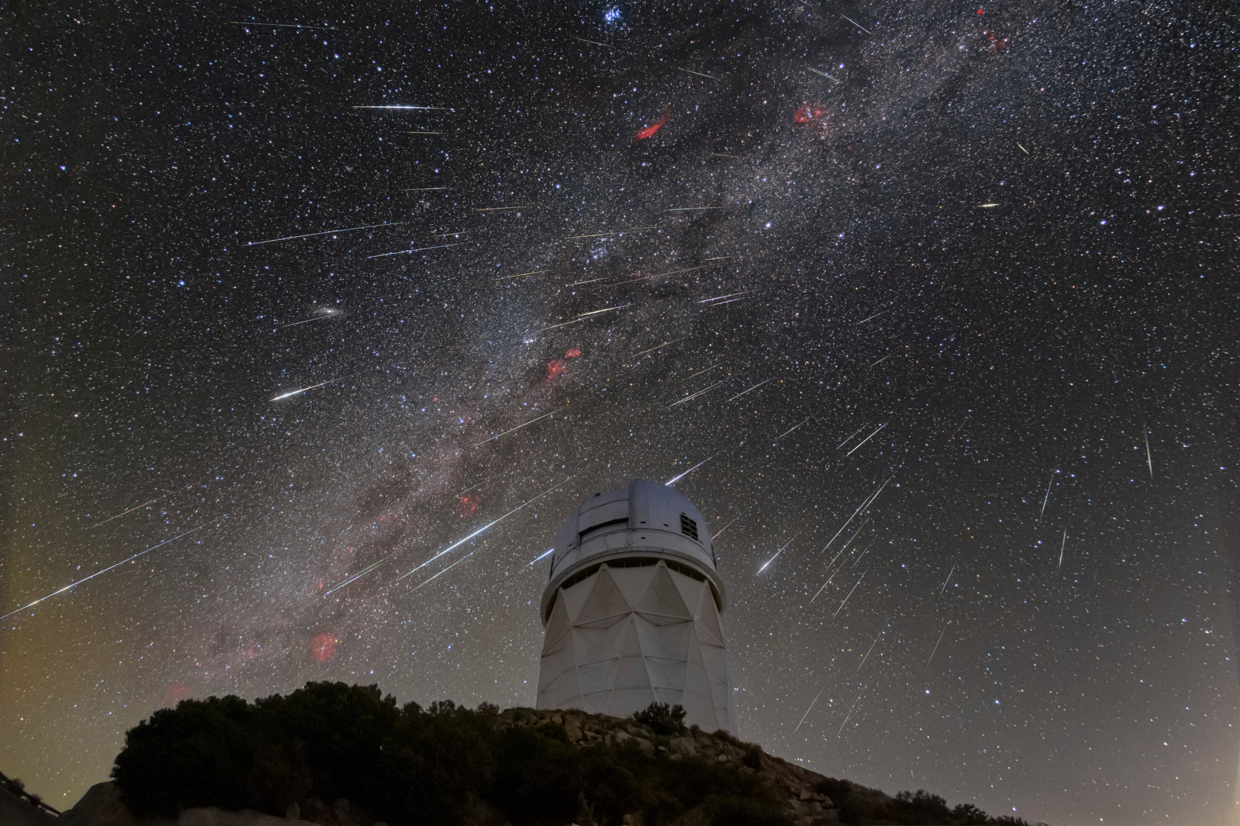 FILE - In this Dec. 14, 2023 photo provided by NOIRLab, meteors from the Geminid meteor shower streak across the sky above the Nicholas U. Mayall Telescope at Kitt Peak National Observatory (KPNO), a program of the National Science Foundation's NOIRLab, located about 56 miles (90 kilometers) southwest of Tucson in the Tohono O'odham Nation. (NSF/NOIRLab via AP, File)