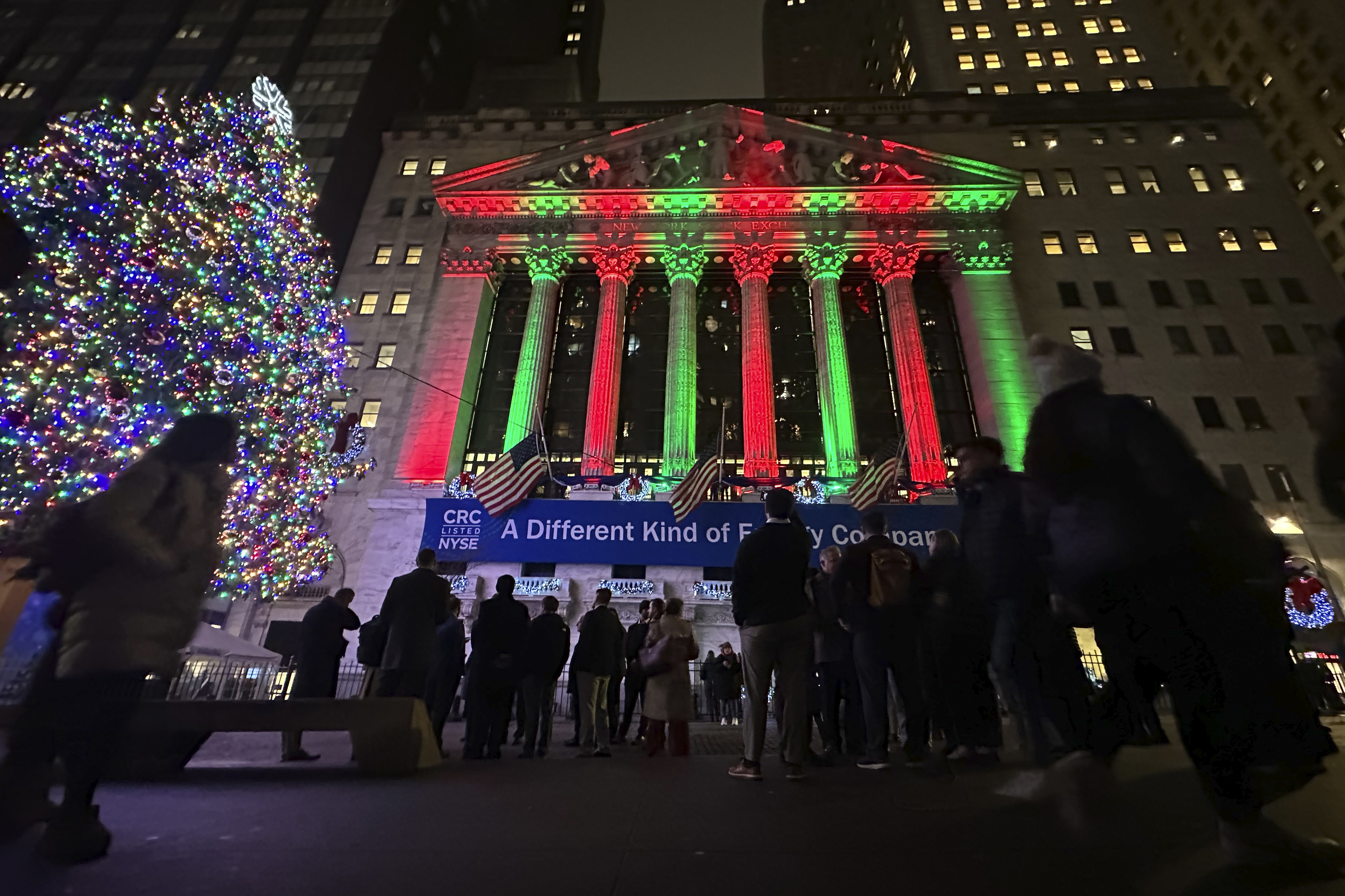 People gather in front of the New York Stock Exchange in New York's Financial District on Tuesday, Dec. 10, 2024. (AP Photo/Peter Morgan)