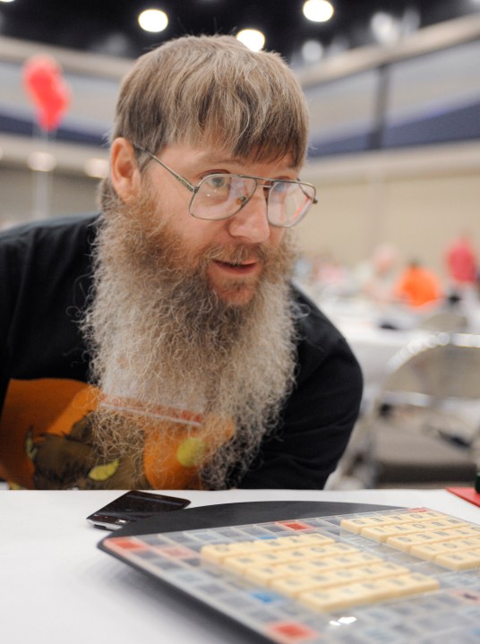 FILE - Tournament favorite and five-time English-language scrabble world champion Nigel Richards looks across the board before the start of his final round, Wednesday, Aug. 13, 2014, at the National Scrabble Championships in Buffalo, N.Y. (AP Photo/Gary Wiepert, File)