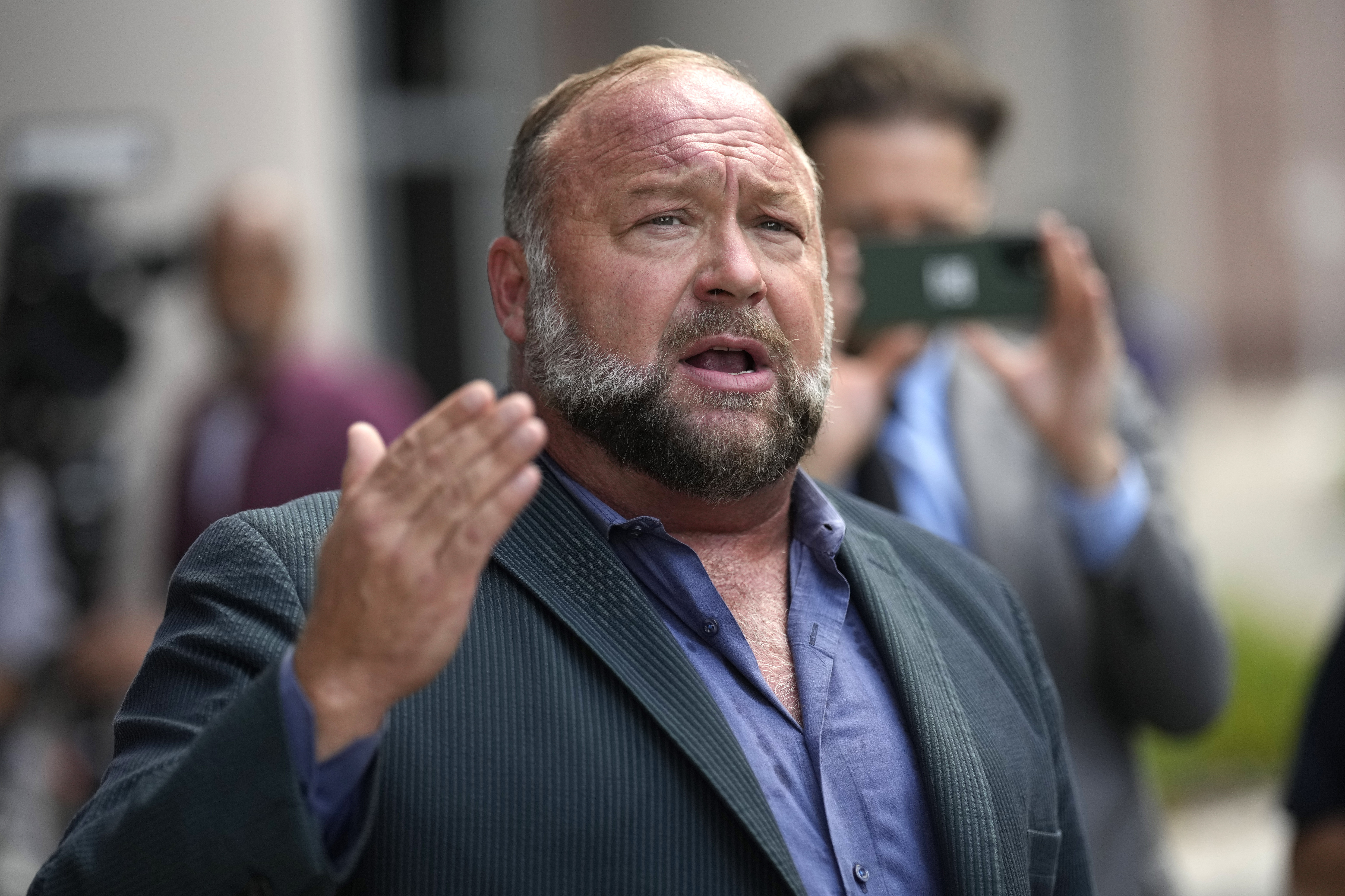 FILE - Alex Jones speaks to the media after arriving at the federal courthouse for a hearing in front of a bankruptcy judge, June 14, 2024, in Houston. (AP Photo/David J. Phillip, file)