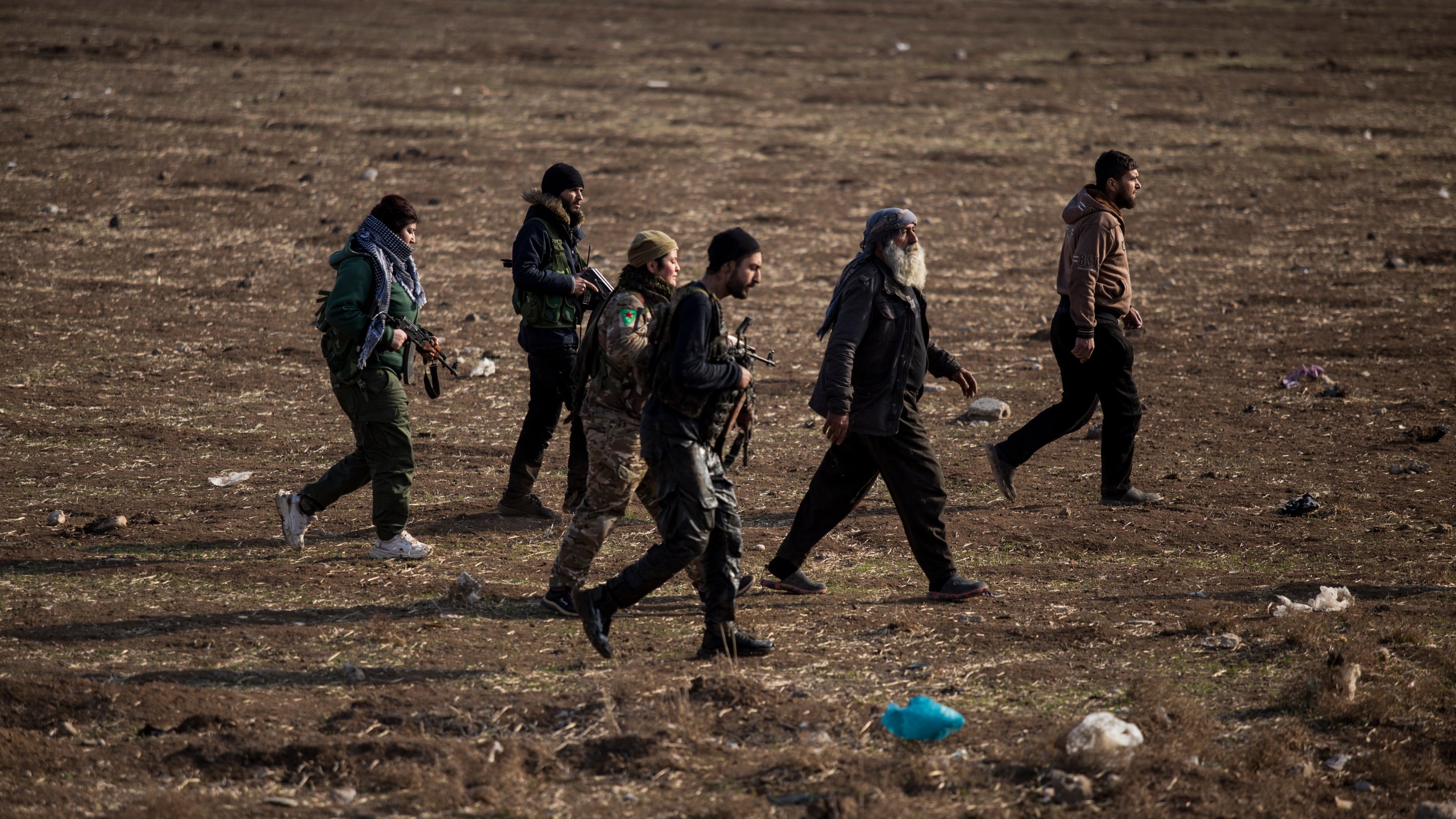 FILE - Kurdish-led fighters backed by the U.S. escort suspected Islamic State militants in Hassakeh, Syria, on Jan. 26, 2022. (AP Photo/Baderkhan Ahmad, File)