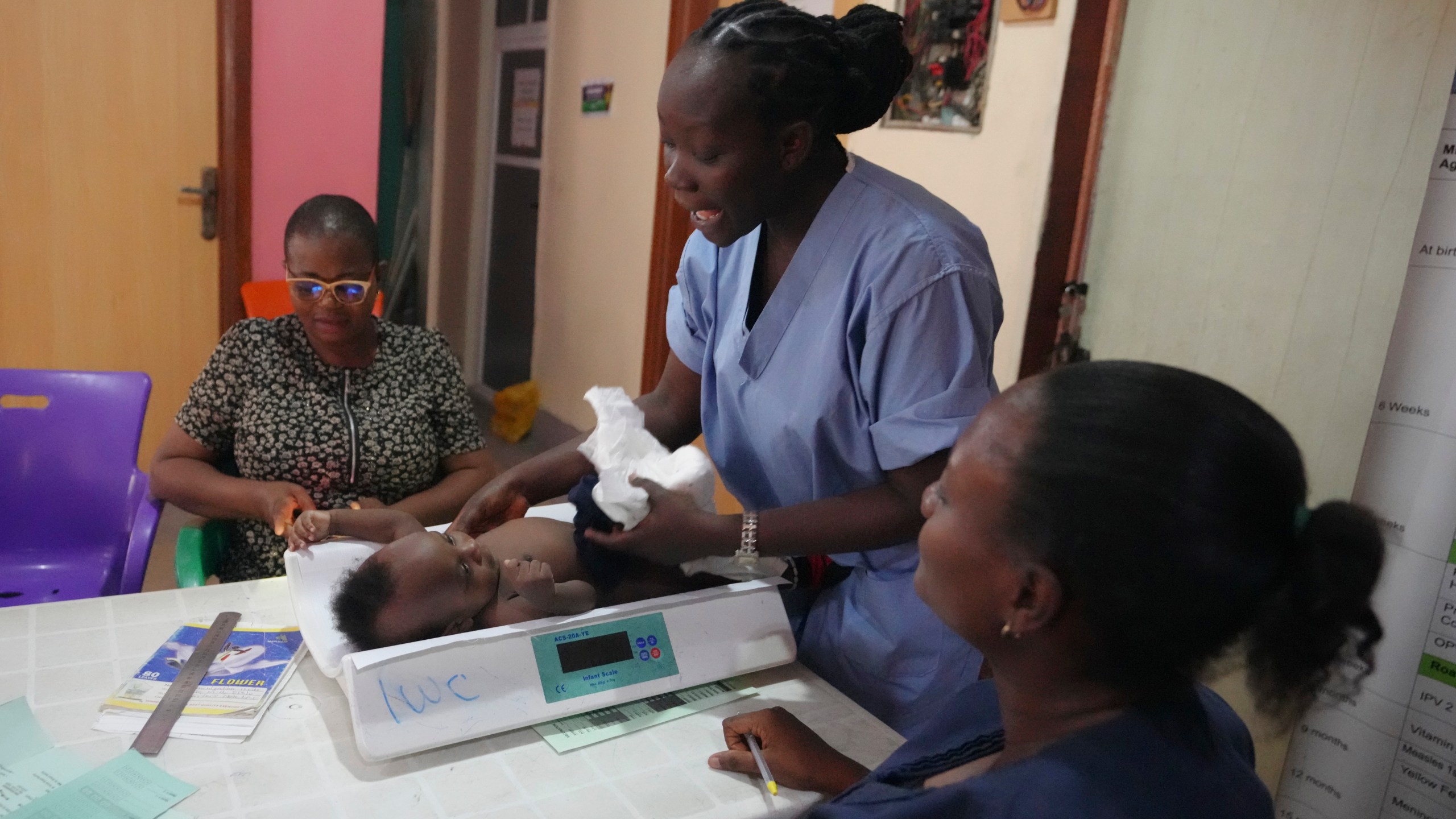 A child is weighed on a scale before he is administered the malaria vaccine R21/Matrix-M at the Health Centre in Yenagoa, Nigeria, Tuesday, Dec. 10, 2024. (AP Photo/Sunday Alamba)