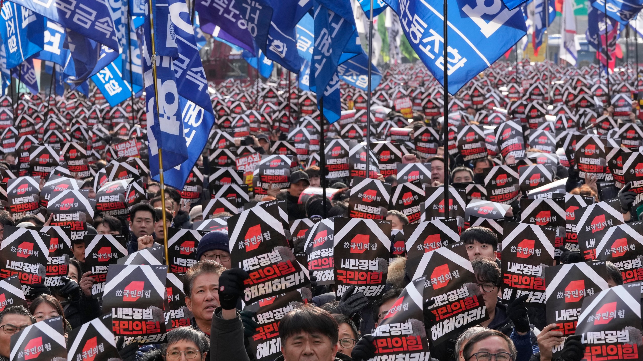 Protesters stage a rally to demand South Korean President Yoon Suk Yeol's impeachment in Seoul, South Korea, Thursday, Dec. 12, 2024. The signs read "Disband the ruling People Power Party." (AP Photo/Ahn Young-joon)