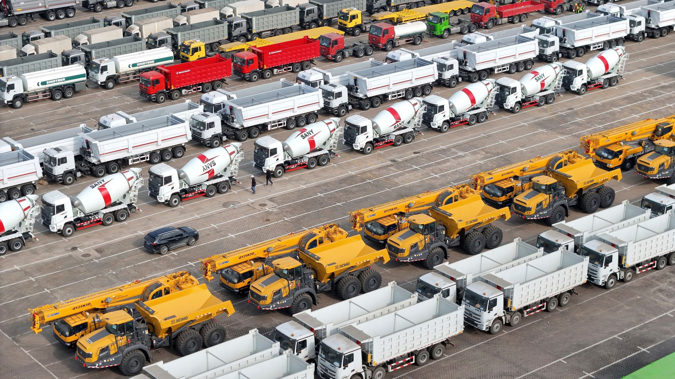 Trucks and engineering vehicles for export wait for transportation from a port in Yantai in eastern China's Shandong province Tuesday, Nov. 19, 2024. (Chinatopix Via AP)