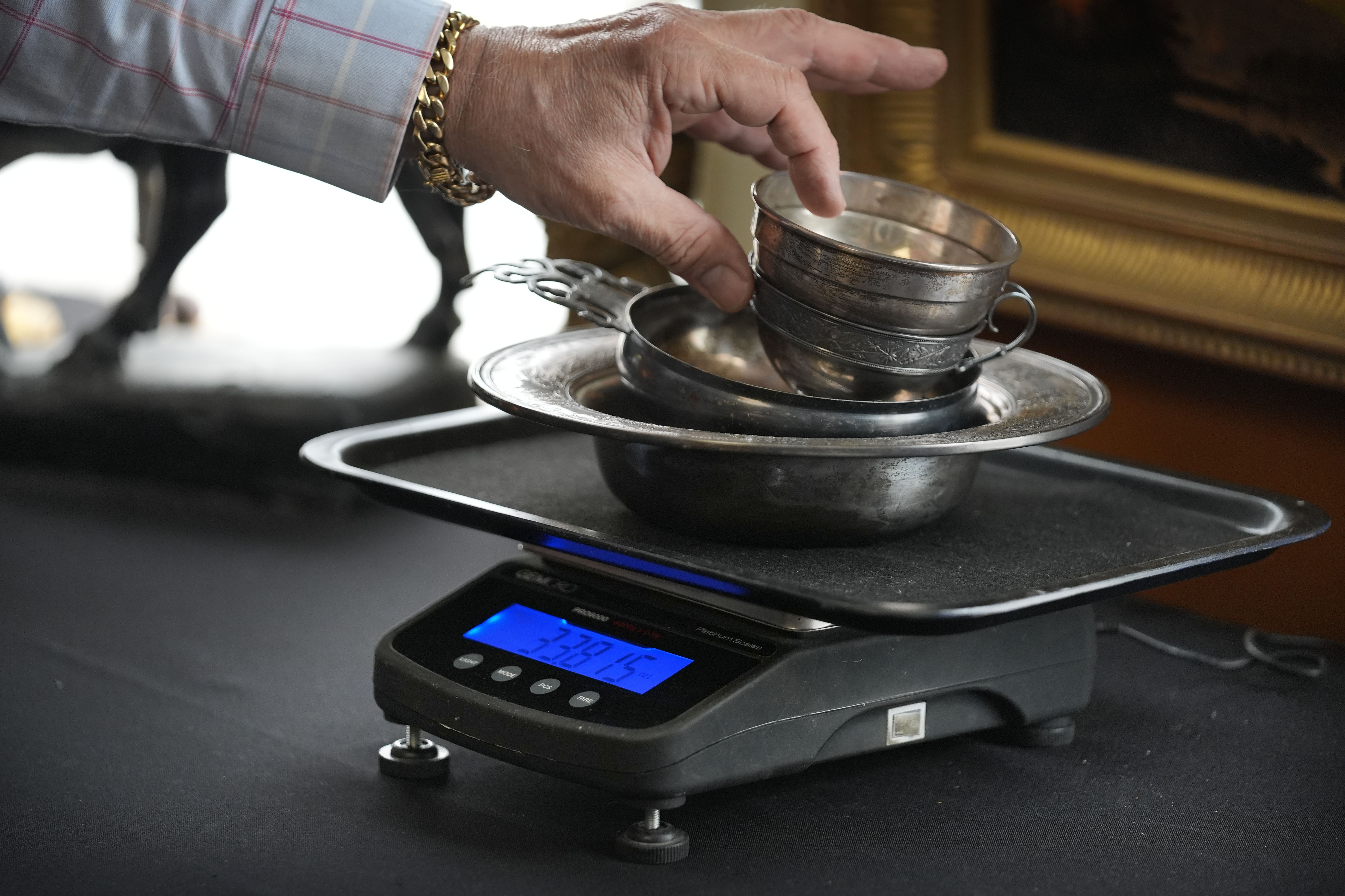 Silverware is weighed during an appraisal at Thomaston Place Auction Galleries, Tuesday, Nov. 19, 2024, in Thomaston, Maine. (AP Photo/Robert F. Bukaty)