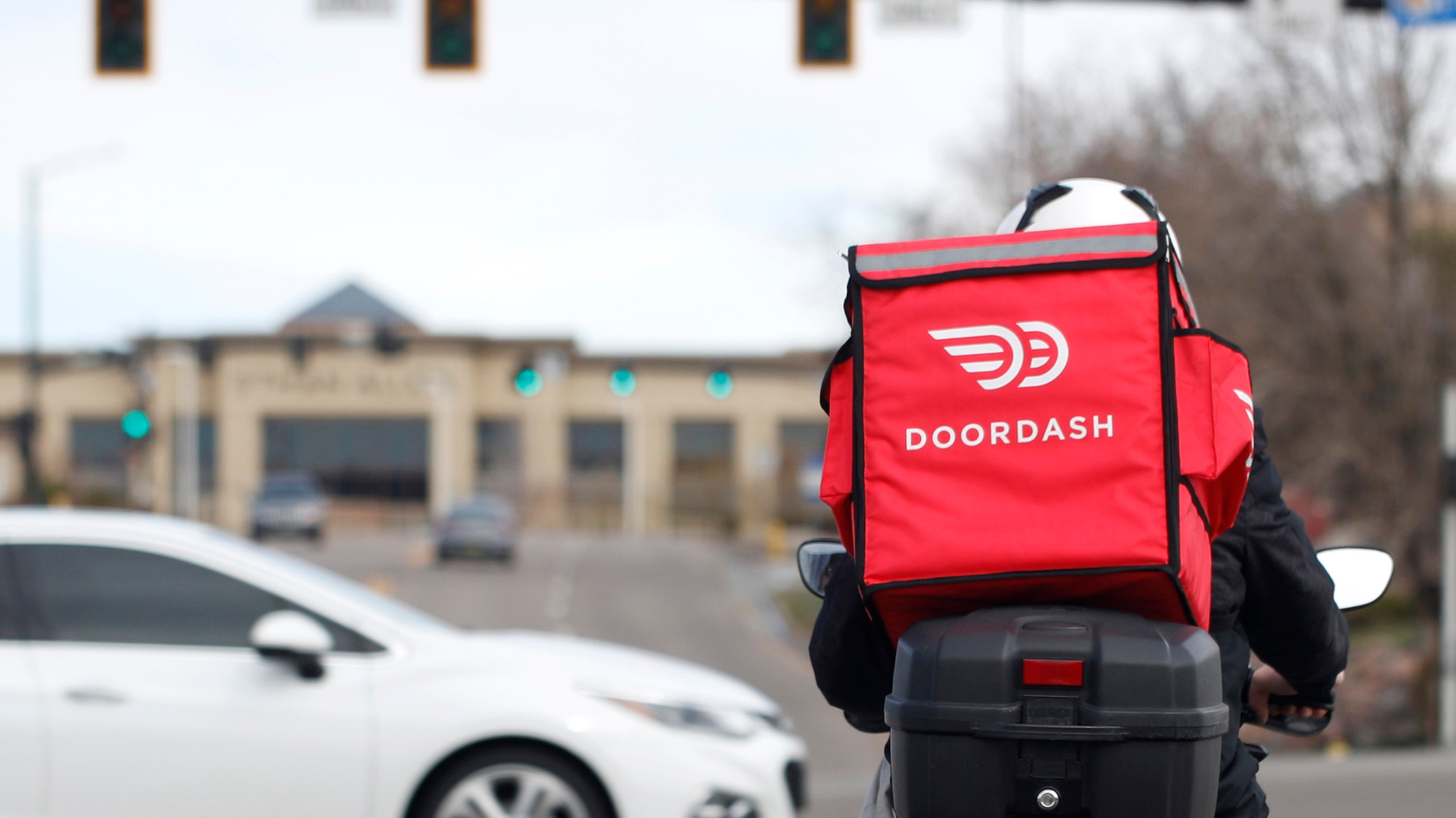 FILE - A food delivery rider waits for the traffic light to change Monday, March 30, 2020, in Lone Tree, Colo. (AP Photo/David Zalubowski, File)