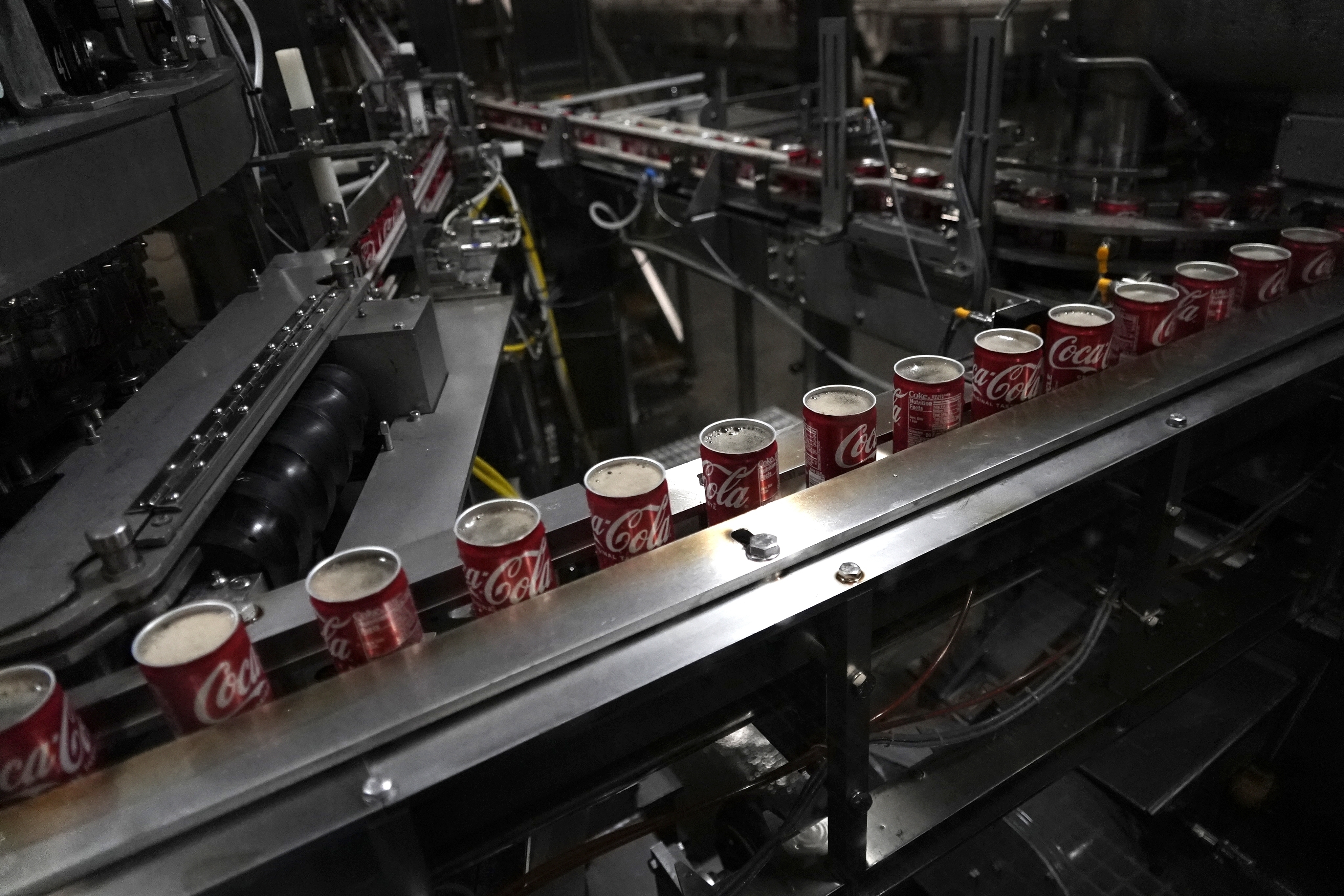 FILE - Coca-Cola cans move down a conveyer belt in the Swire Coca-Cola bottling plant Oct. 20, 2023, in Denver. (AP Photo/Brittany Peterson, File)