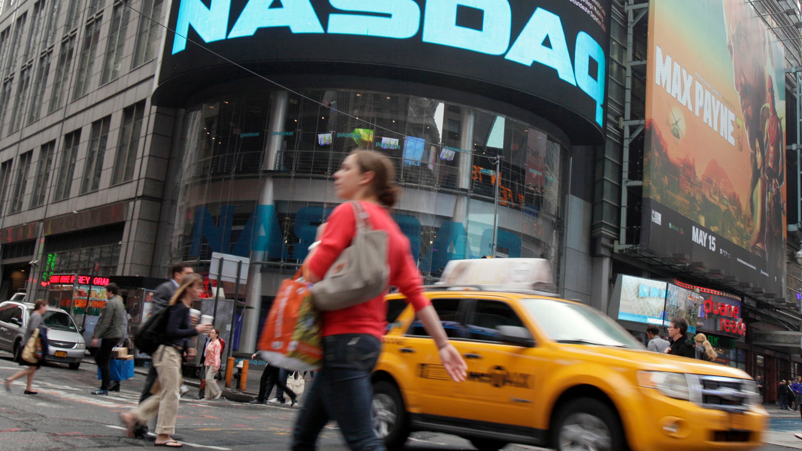 FILE - Commuters traverse New York's Times Square in front of the Nasdaq MarketSite, Wednesday, May 16, 2012. (AP Photo/Richard Drew, File)