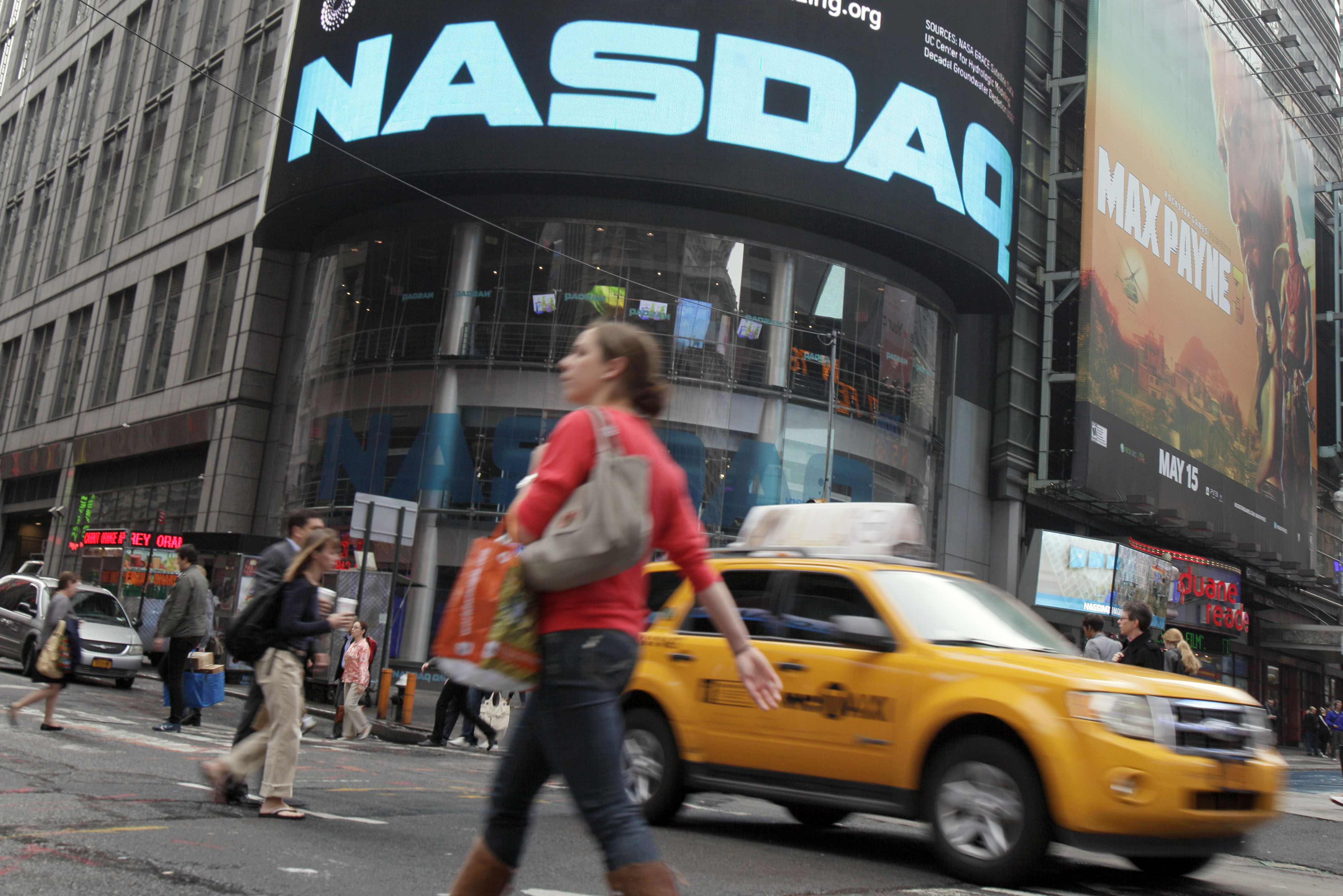 FILE - Commuters traverse New York's Times Square in front of the Nasdaq MarketSite, Wednesday, May 16, 2012. (AP Photo/Richard Drew, File)