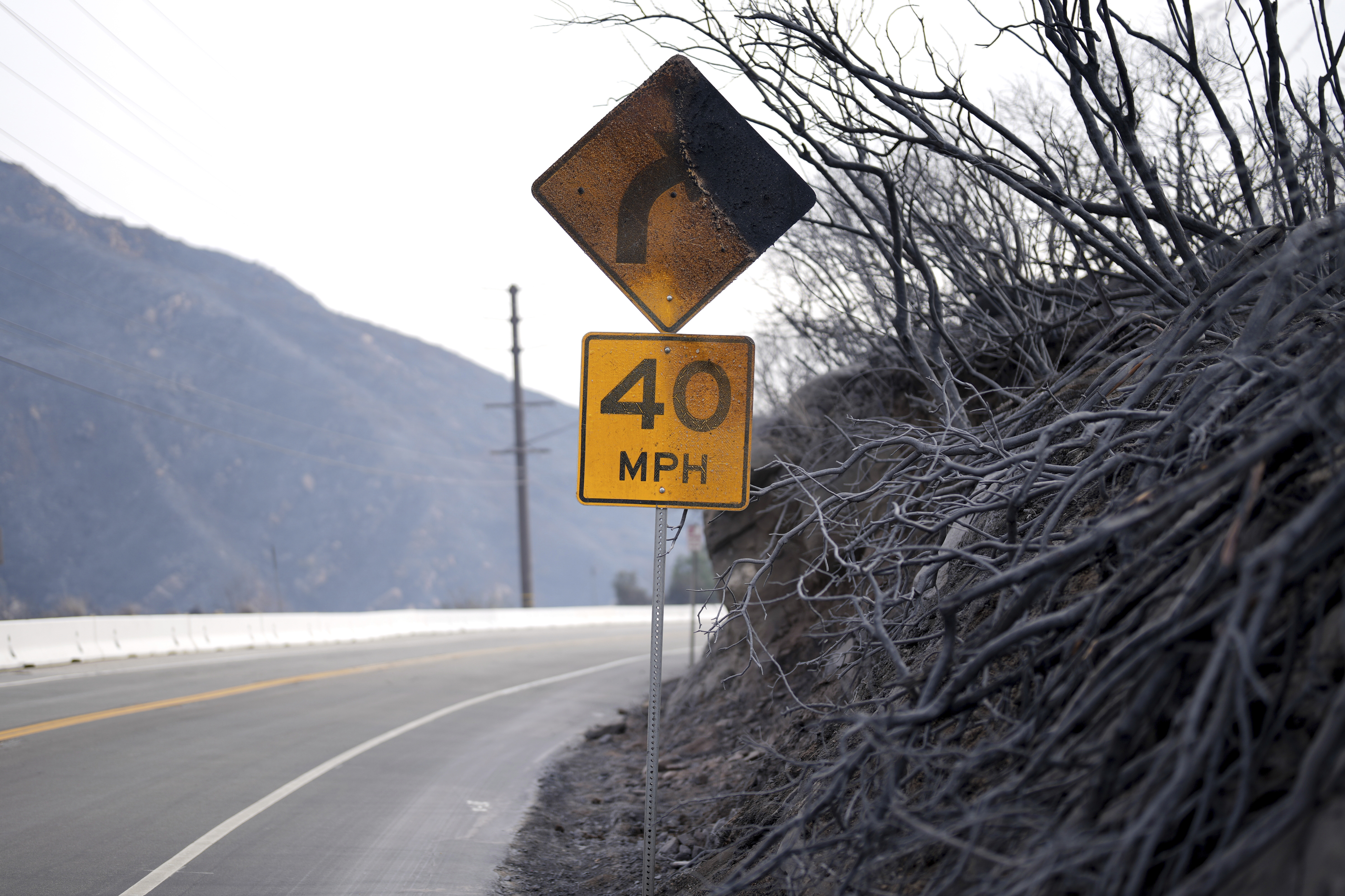 A road signed is burned after the Franklin Fire swept through Wednesday, Dec. 11, 2024, in Malibu, Calif. (AP Photo/Eric Thayer)